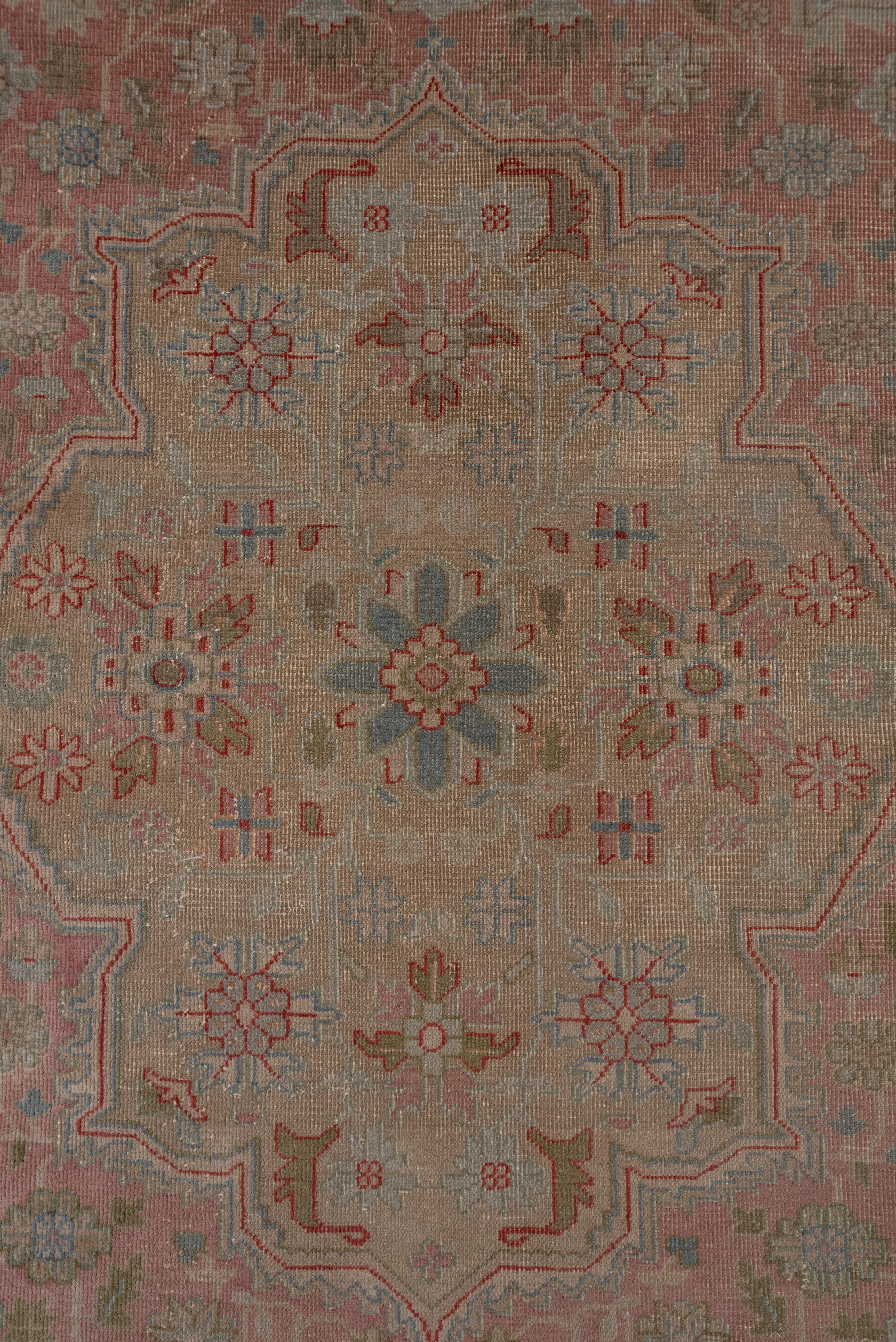 This light colored eastern Turkish workshop carpet in the Heriz style features an oatmeal field with angular arabesques and vines supporting a tall stepped and lobed tan medallion. An assortment of floral stems decorates the main border.
    