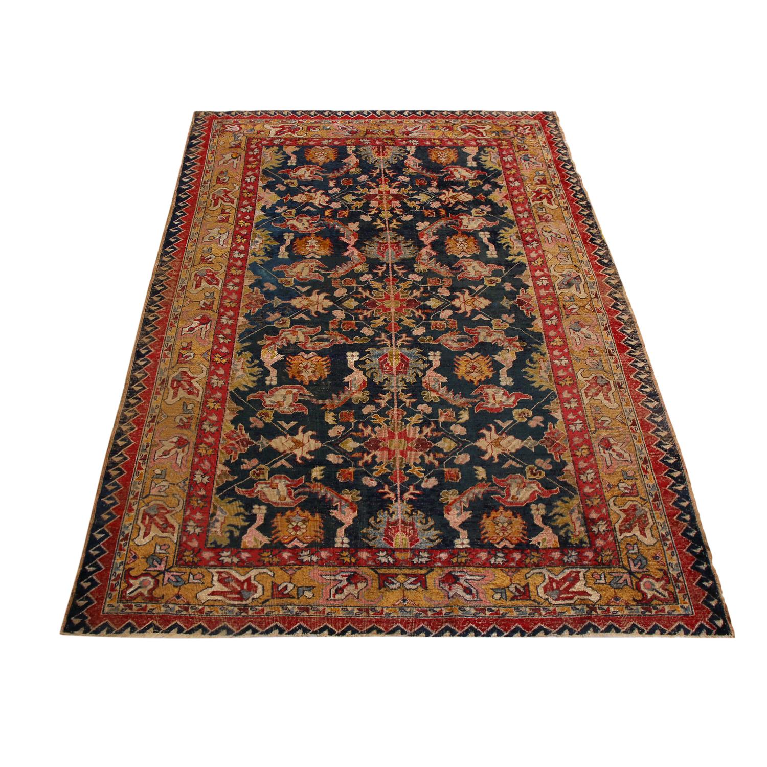 Enjoying a very tribal geometric-floral design and hand knotted, naturally luminous silk originating from Turkey in 1890, this antique Sivas rug is an ode to masterful symmetry in color and pattern, mirrored from the center outward in an
