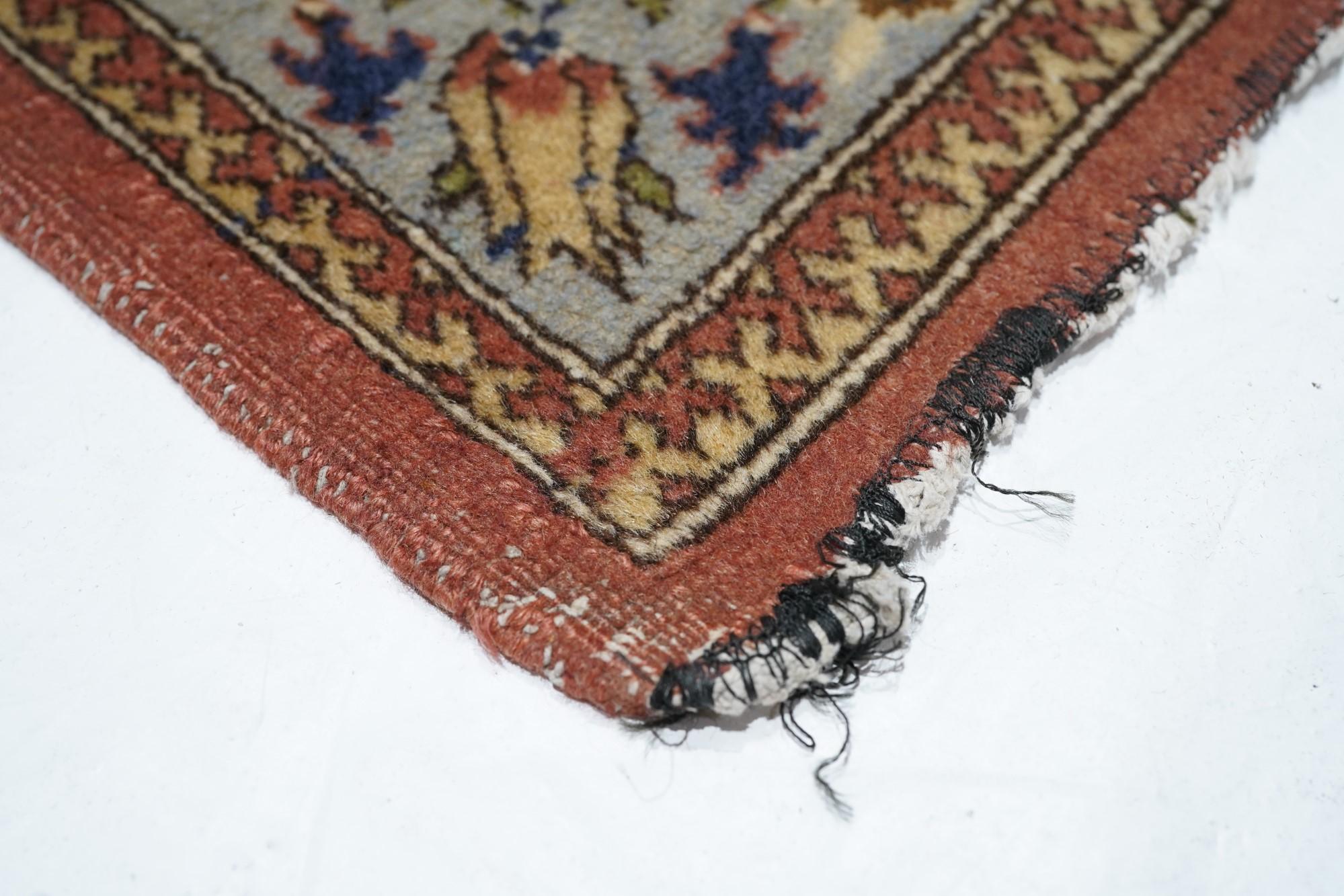 Ce tapis d'atelier de l'est de l'Anatolie présente un champ beige étroitement décoré de rangées décalées, en demi-goutte, de bouquets floraux uniformes et serrés. Bordure principale écrue avec vinerie en volute, arabesques fourchues et petites