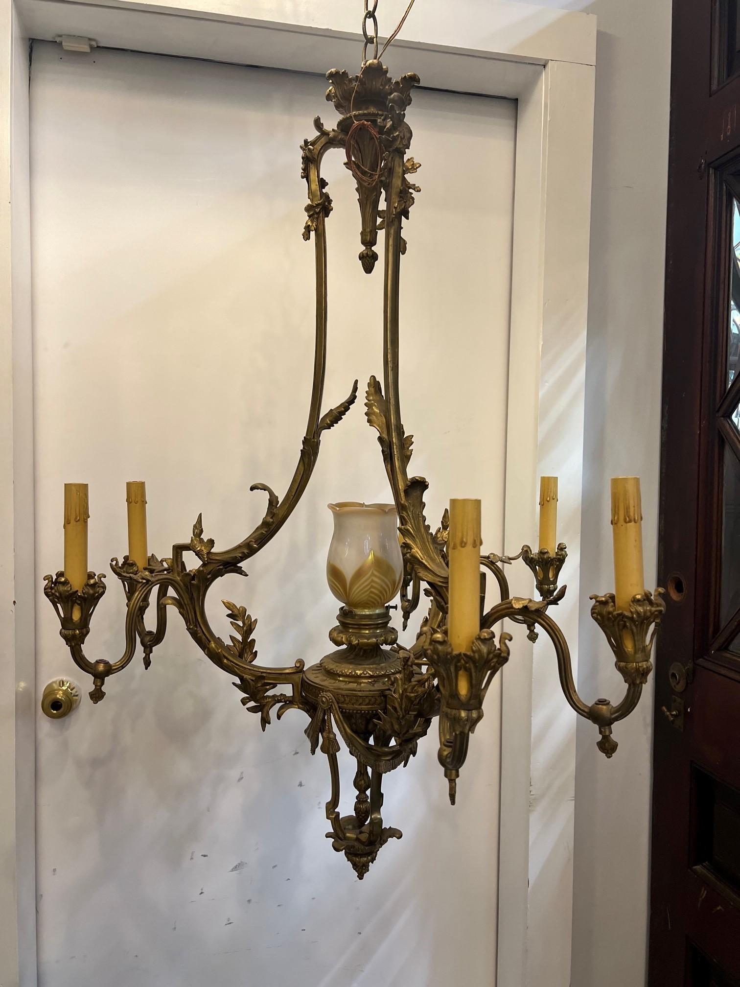  Antique French Louis XV style bronze chandelier with a center glass globe. It has three decorative arms with two candelabra lights on each and one light in the center with a art glass globe. The chandelier has been wired recently and the glass