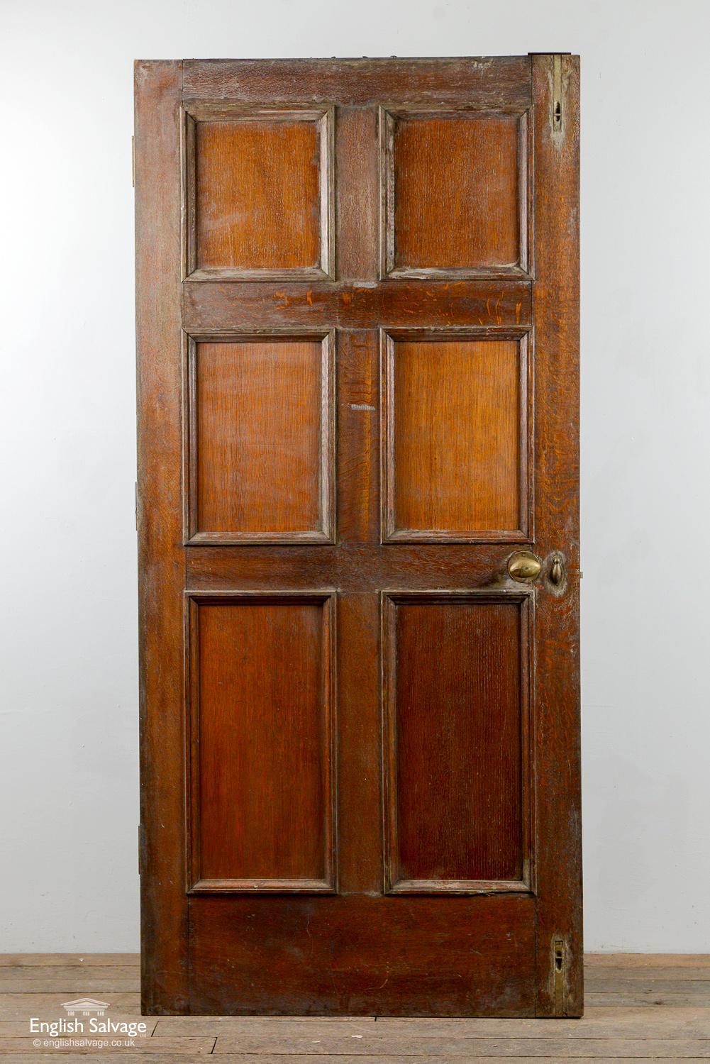 Reclaimed antique oak door with six beaded panels to the front, and six plain panels to the reverse. Three old hinges present and lock, handle and nail holes. Wear commensurate with age.