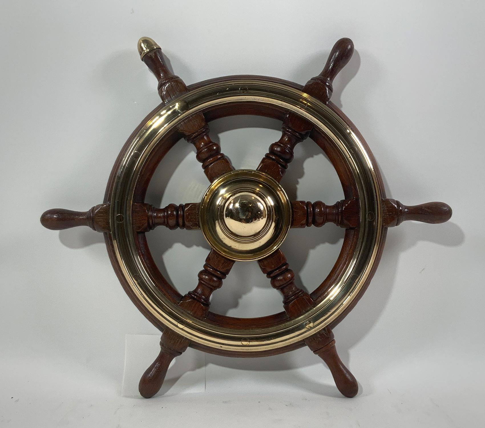 Small boat or yacht wheel with varnish finish and highly polished brass hub and trim ring. This is an exceptional little relic. Circa 1890. English made.

Weight: 8 LBS
Overall Dimensions: 18