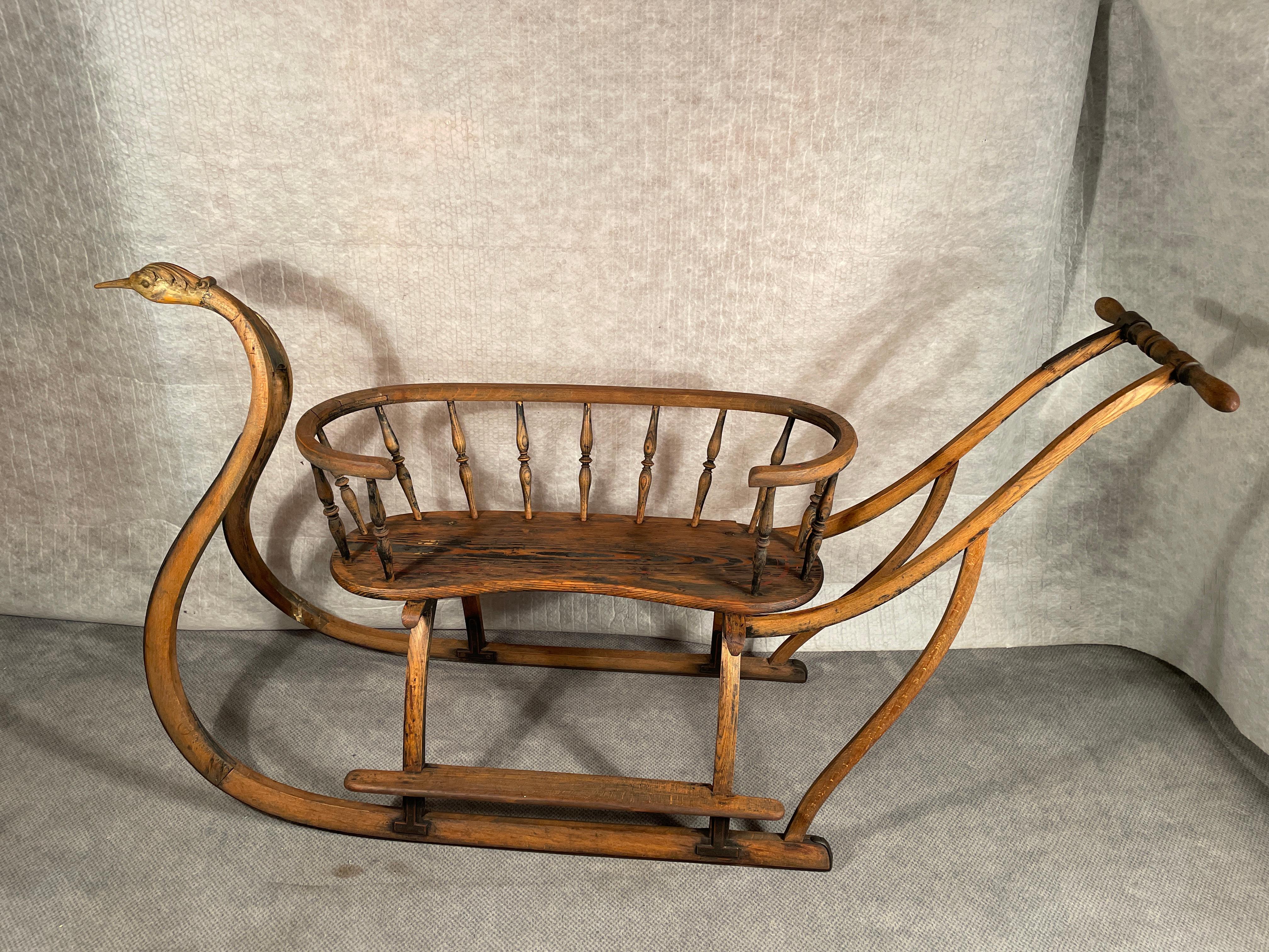 Very rare antique sled coming from Switzerland and dating back to the first half of the 19th century. 
The wooden sled shows some remaining color and gilding. The curved skids are decorated at the front end with a naturalistically hand-carved