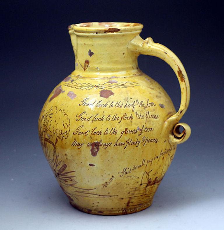 A good earthenware slip glaze scraffito decorated harvest pitcher named and dated 