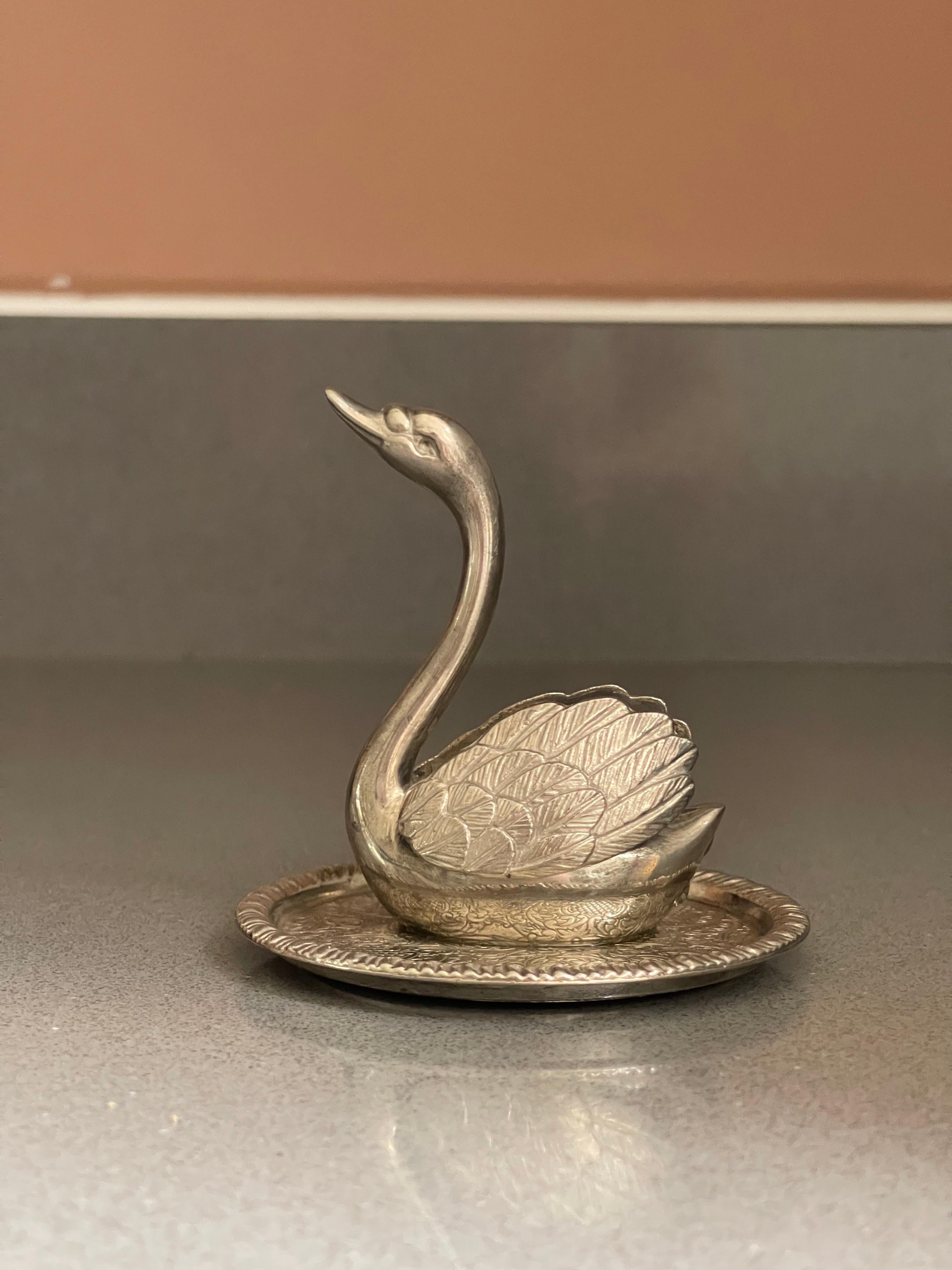 Add a touch of vintage charm to your jewellery collection with this beautiful swan ring holder. Crafted from high-quality metal with silver plating, it is the perfect addition to any jewellery organiser. The swan's elegant shape and intricate