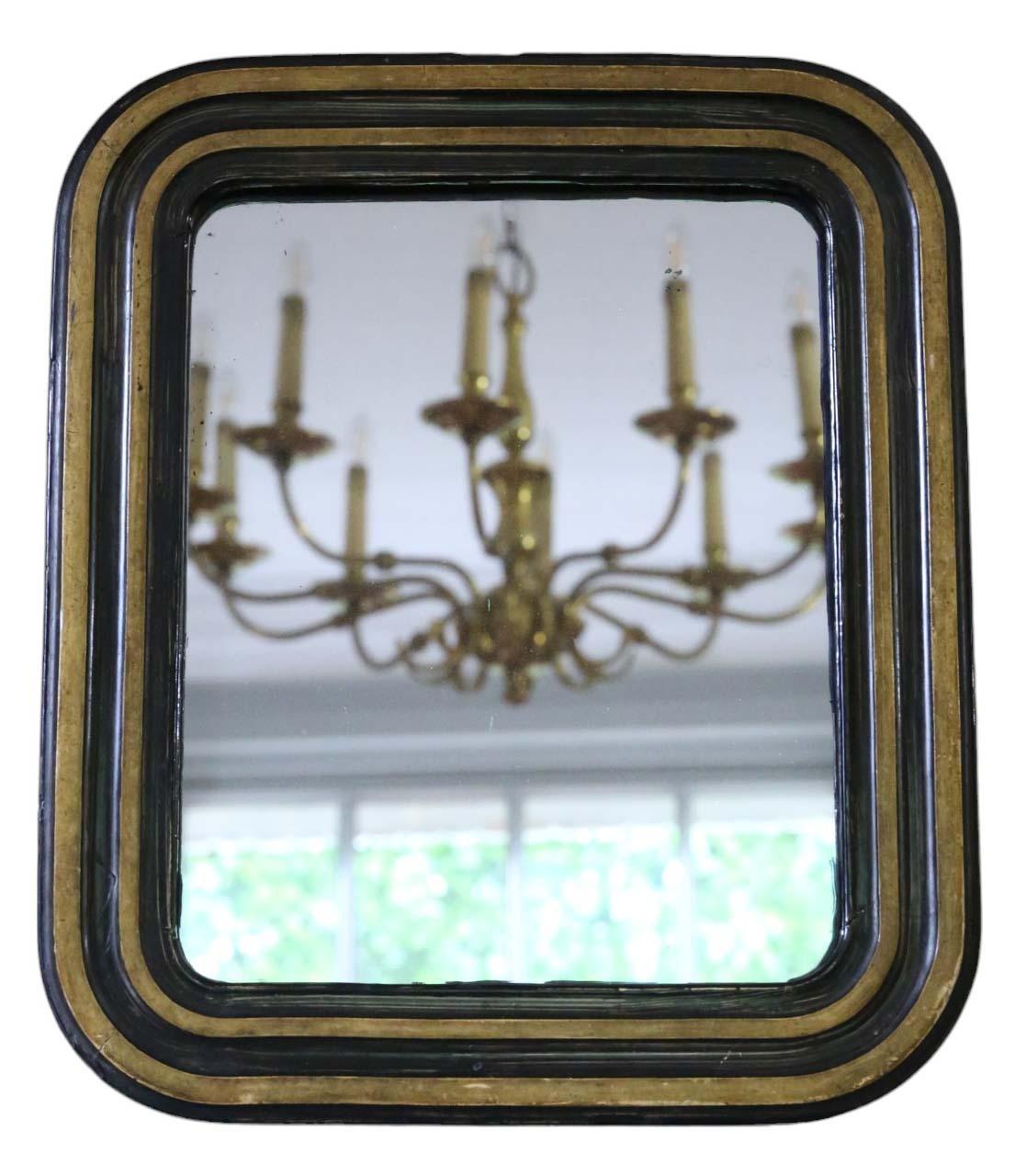 Antique small gilt and ebonized overmantle wall mirror from the 19th Century, boasting quality craftsmanship.

This mirror captivates with its modest proportions, adding character to any suitable space. The frame exhibits sturdy construction, free