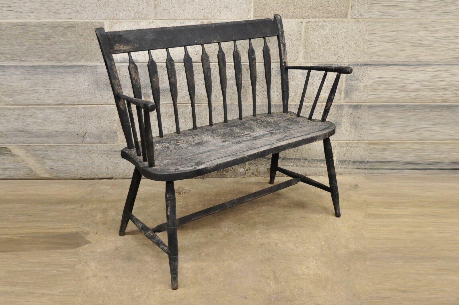 Antique Small Arrow Back Black Distress Painted Wooden Primitive Bench. Item features a carved arrow back, plank seat, stretcher base, solid wood frame, distressed finish, very nice antique item. Circa Early to Mid 1900s.
Measurements: 32.5