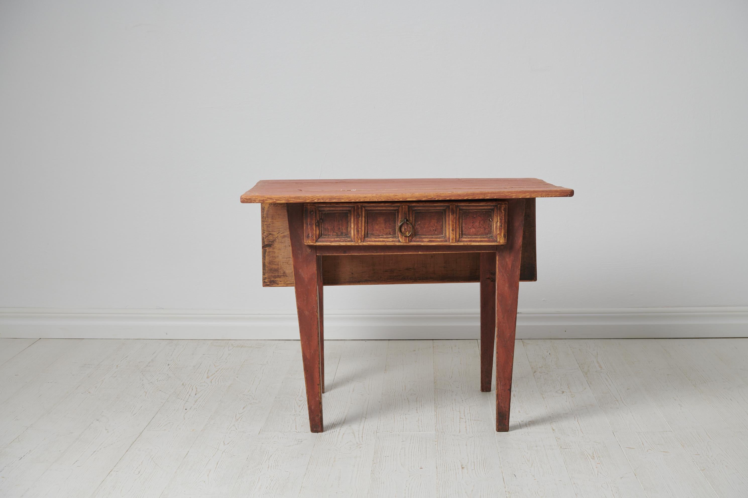 Small charming country table from northern Sweden. The table is a genuine folk art furniture from around 1790 to 1810. It is made by hand in solid pine. The table is in untouched condition with the original paint which has genuine distress and