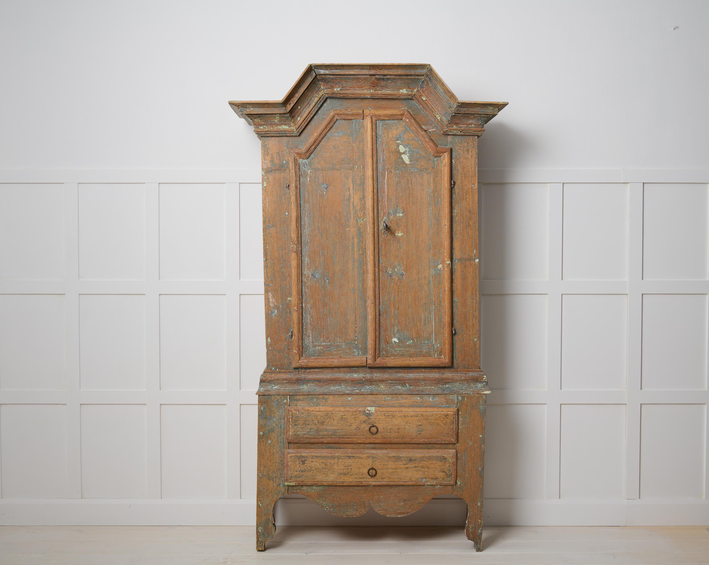 Small antique country cabinet from northern Sweden. The cabinet is a genuine country house furniture made in Jämtland in Sweden around 1820. Made by hand with a frame in solid pine. There are some smaller traces of the original paint still visible