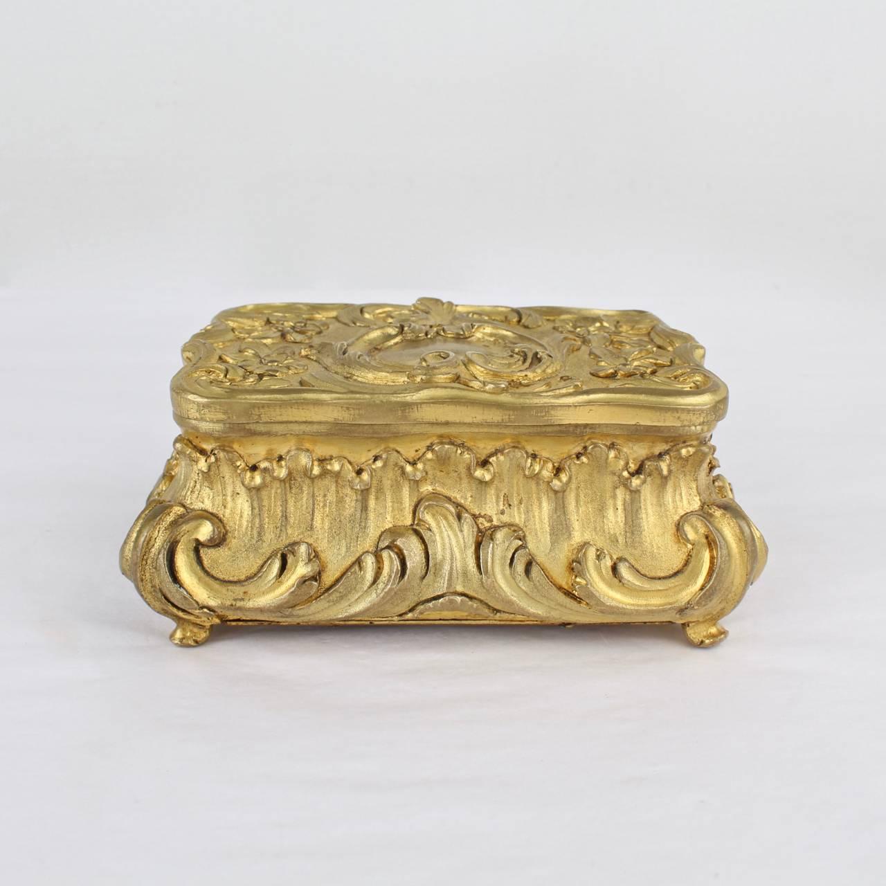 An small, heavy doré gilt bronze box or casket of very good quality.

With a divided interior and hinged lid.

Possibly French and likely 19th century.

With fine casting, surprising weight, and superb design.

Measures: Length ca. 4 1/4