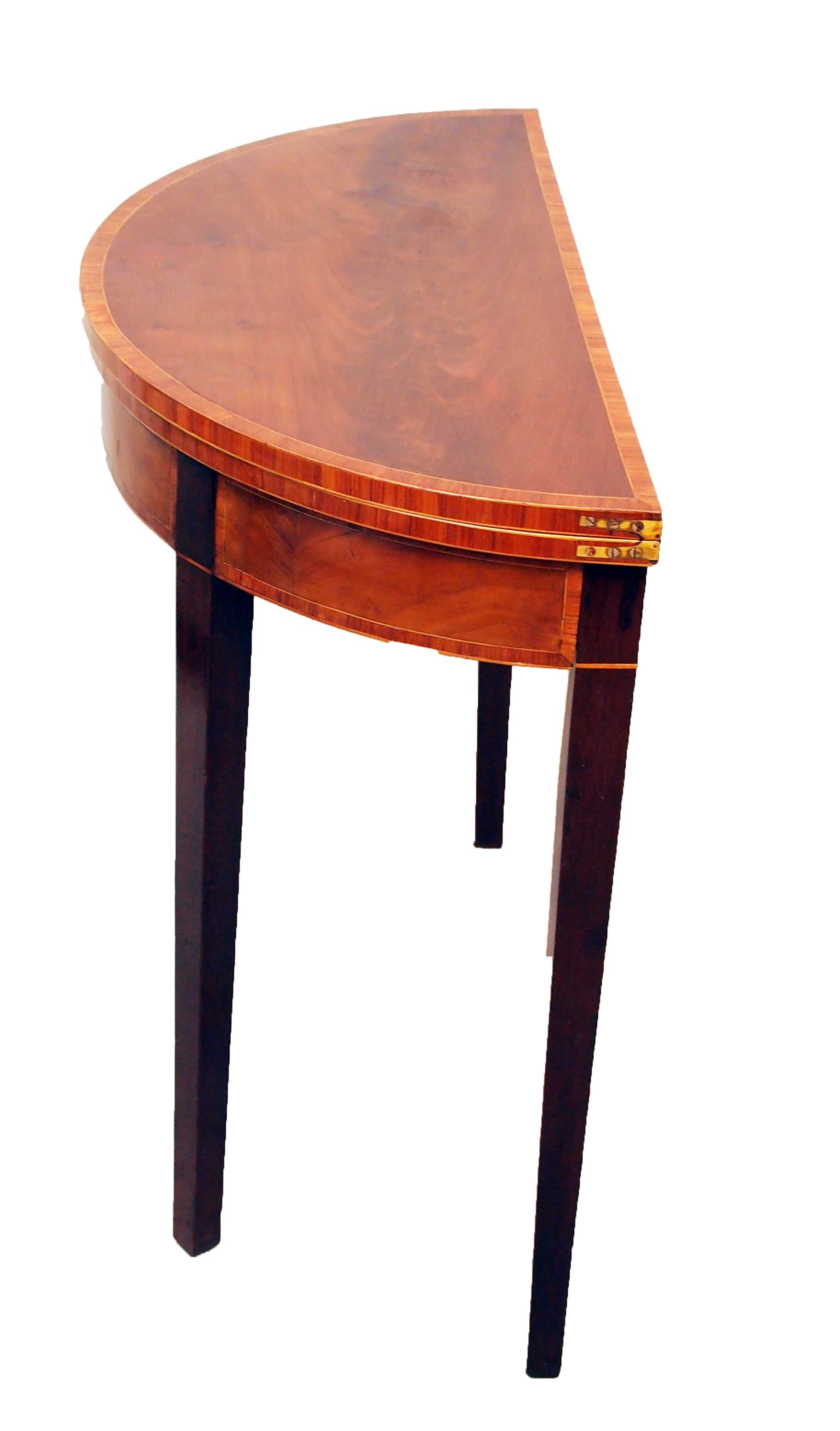 A very good quality George III period mahogany demilune
card table of diminutive proportion having superbly figured
and crossbanded folding top raised on elegant square tapered
legs.