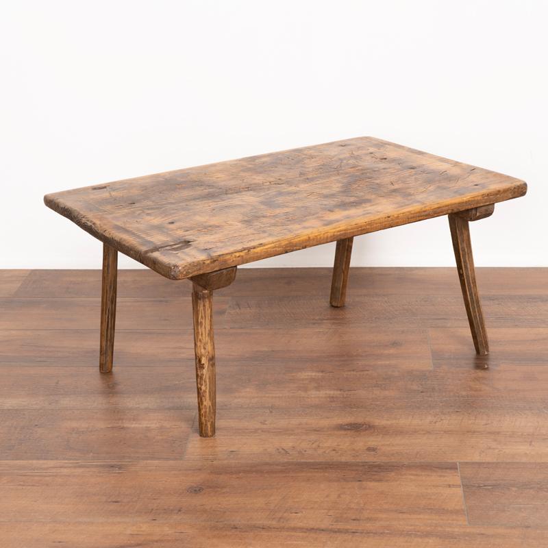 It is the rich, aged patina of the wood that draws one to this small side table that may be used as a table top riser as well. The traditional splay peg legs add to its European country charm. While it once served as a small work table (note the