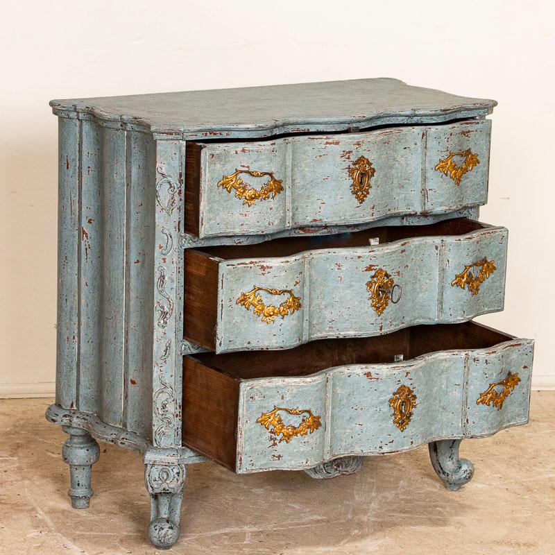 This stunning small chest of drawers is quite dramatic thanks to the (newer) blue painted finish that is perfectly distressed, accenting the Rococo curves and cabriolet feet. The size makes it adaptable to use as a nightstand, side table or simply