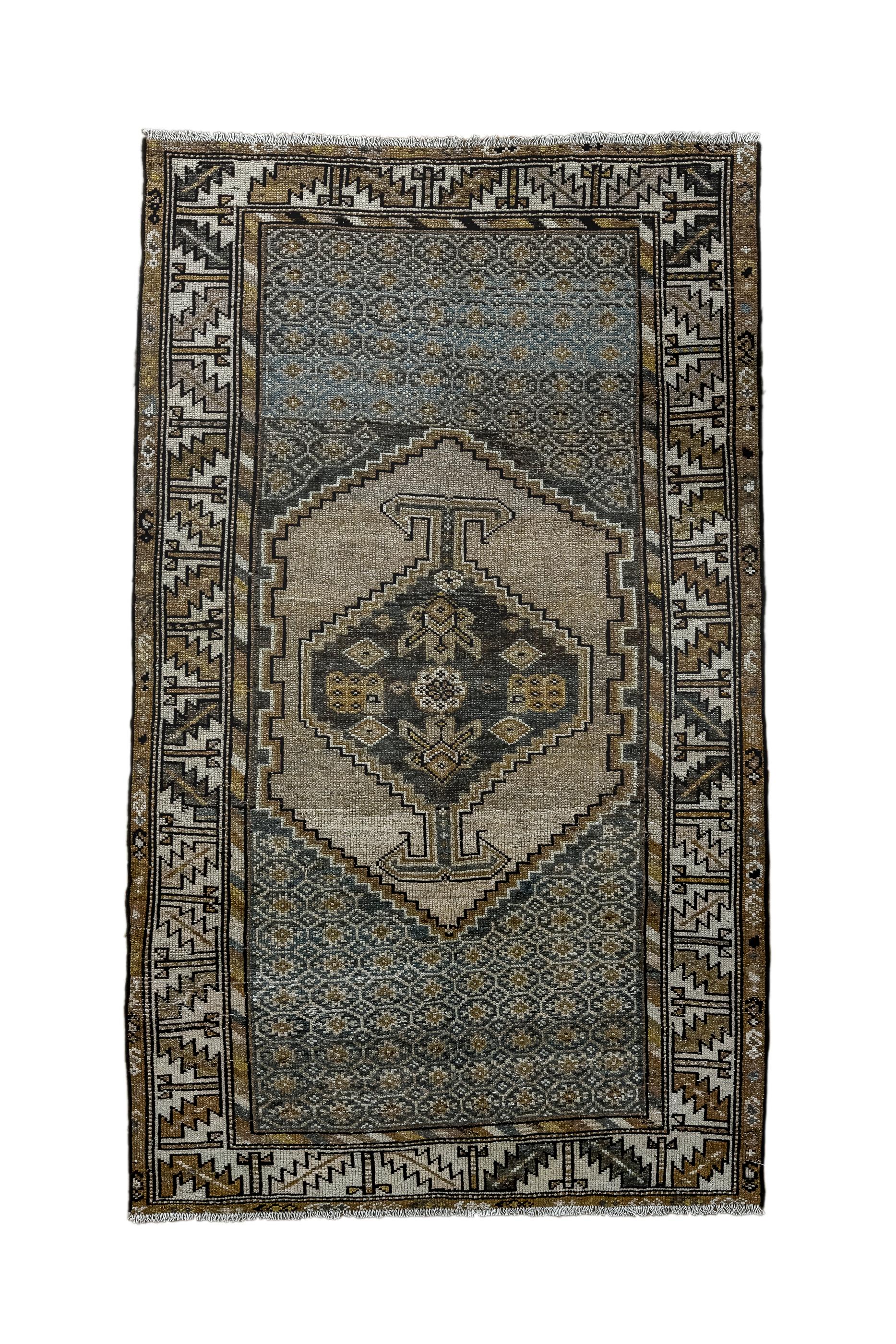 The small, abrashed camel-beige stepped and notched sub-field encloses a relatively conforming hexagonal, medallion with bold anchor pendants. The slate field shows a small lattice of flattened octagons. Caucasian-style ecru border with slanted