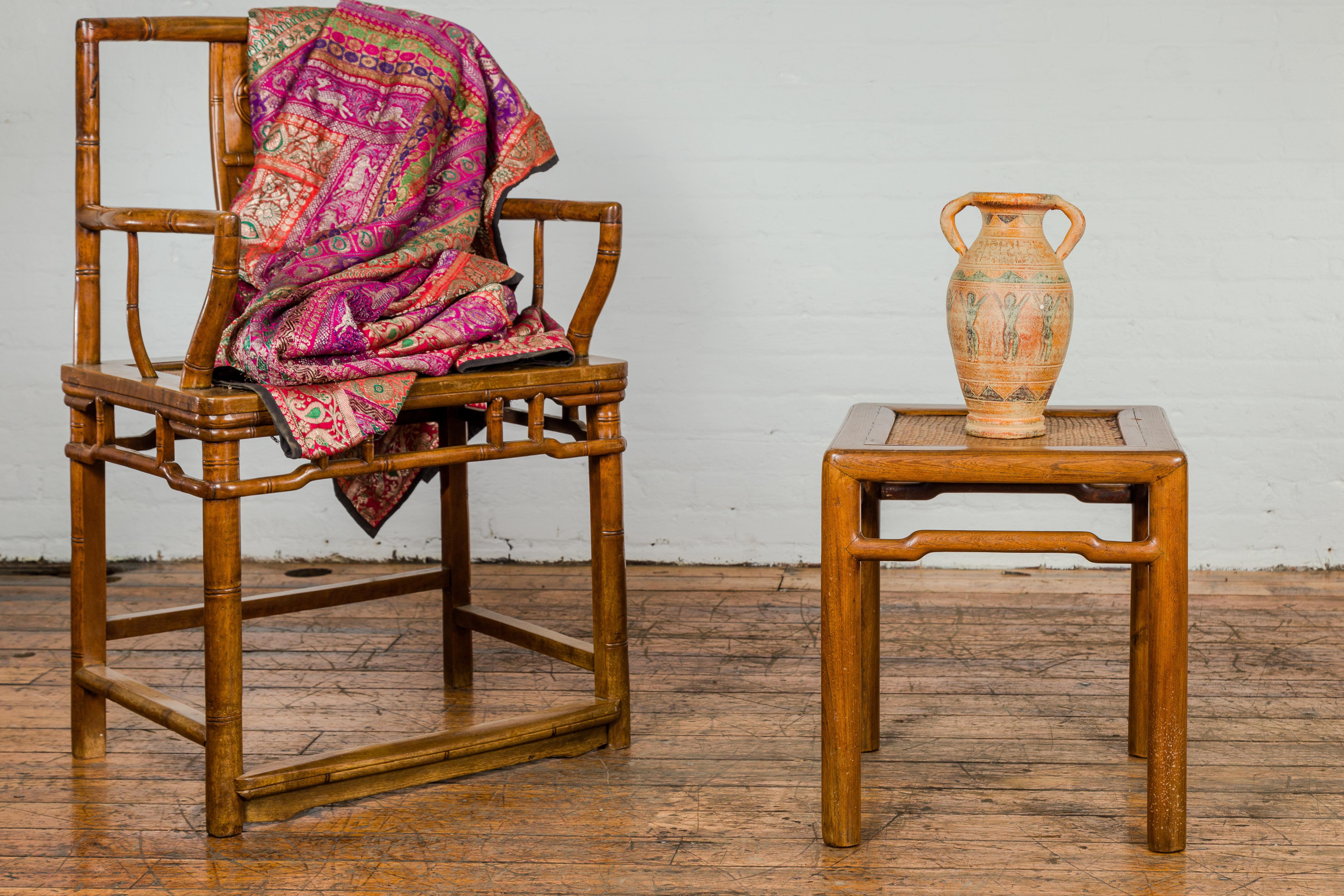 A late Qing Dynasty period small square shaped side table from the early 20th century with rattan insert at the top, humpback stretchers on all sides and cylindrical legs. Imbue your home with a touch of the orient through this late Qing Dynasty