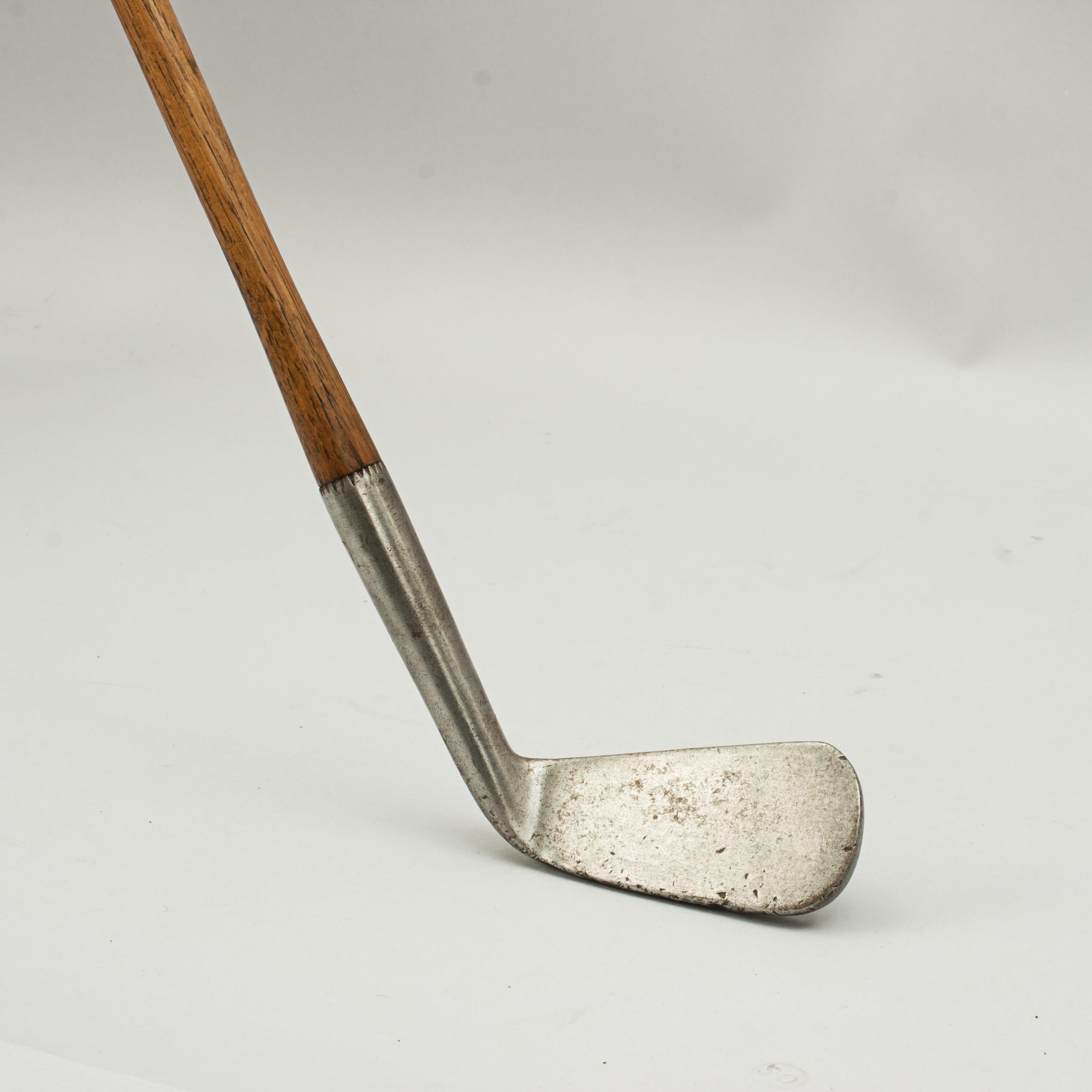 Early left hand hickory golf club.
This early large head hickory shafted lofting iron has a smooth face, hickory shaft and the remains of the original sheepskin grip. This is a fine example of an early lofting iron, maker unknown. The hosel with