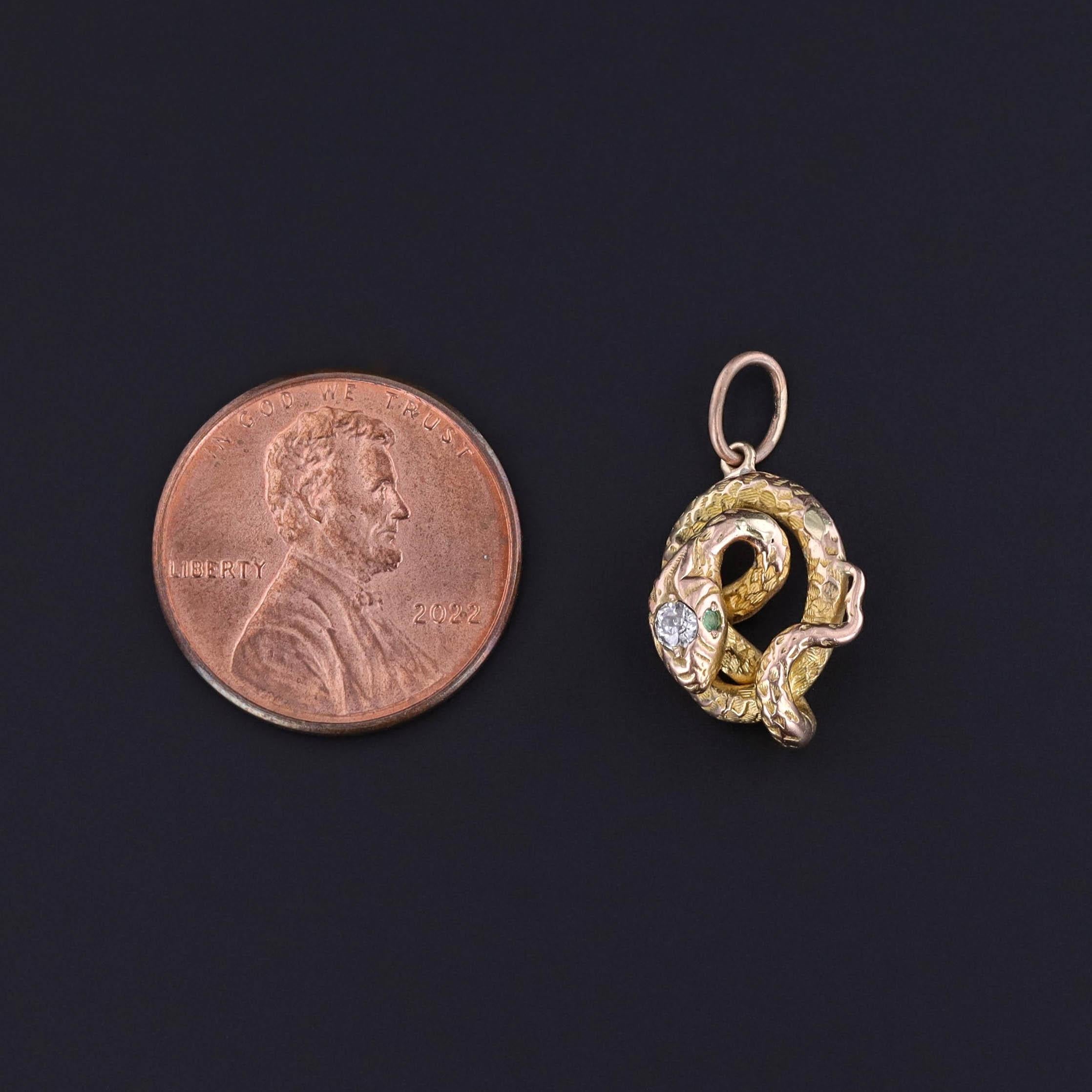 This charm features a snake of 18k gold with an old European cut diamond and two emerald eyes. It was created from an antique stickpin (circa 1900) that our jeweler transformed by removing the pin and adding a jump ring bail.

The piece measures 0.8