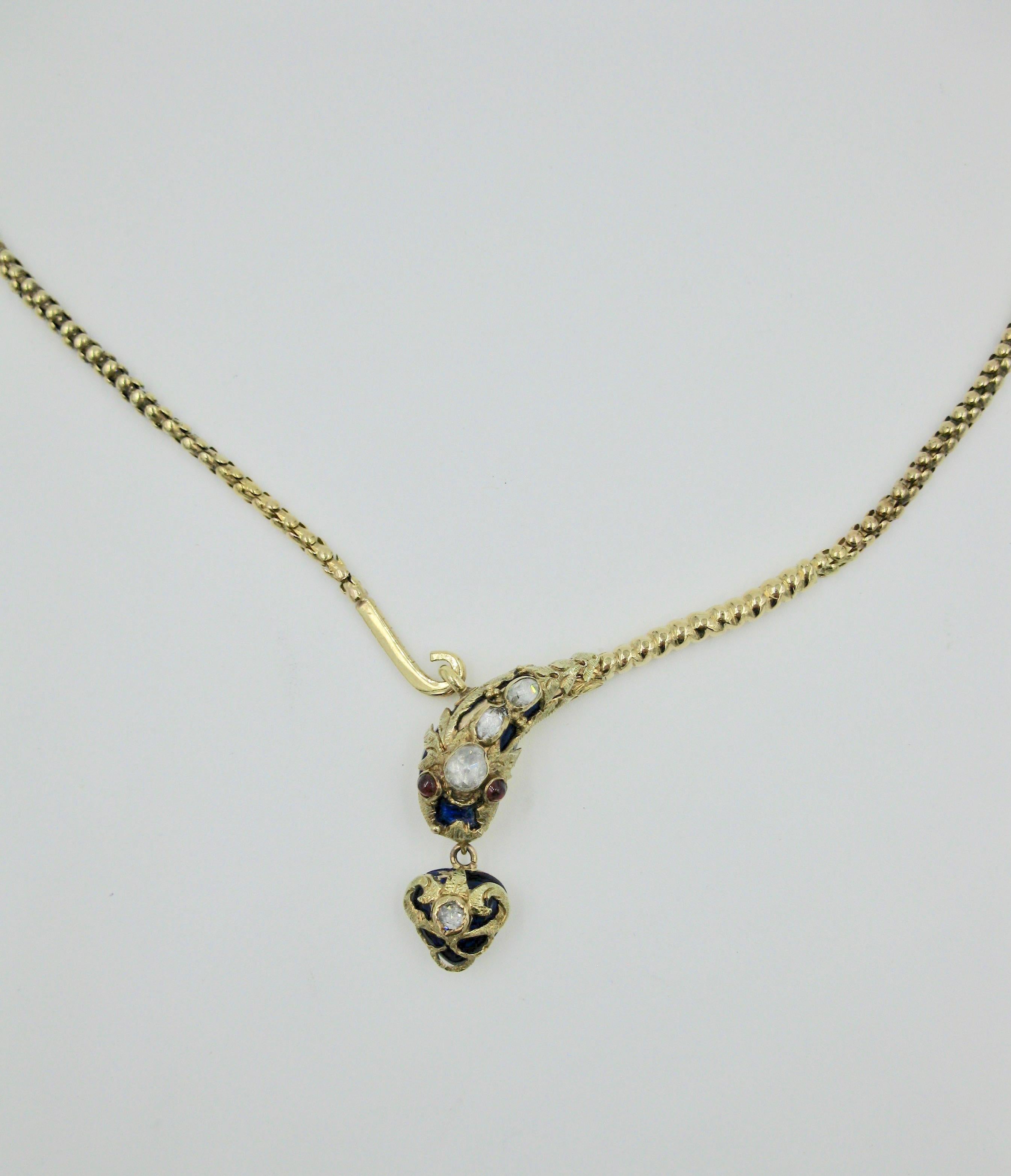 This is a rare antique Victorian Snake Necklace with a Heart Locket Pendant hanging from its mouth.  The snake necklace dating to circa 1840.  The snake head and heart are set with four spectacular Rose Cut Diamonds of great beauty.  The eyes are