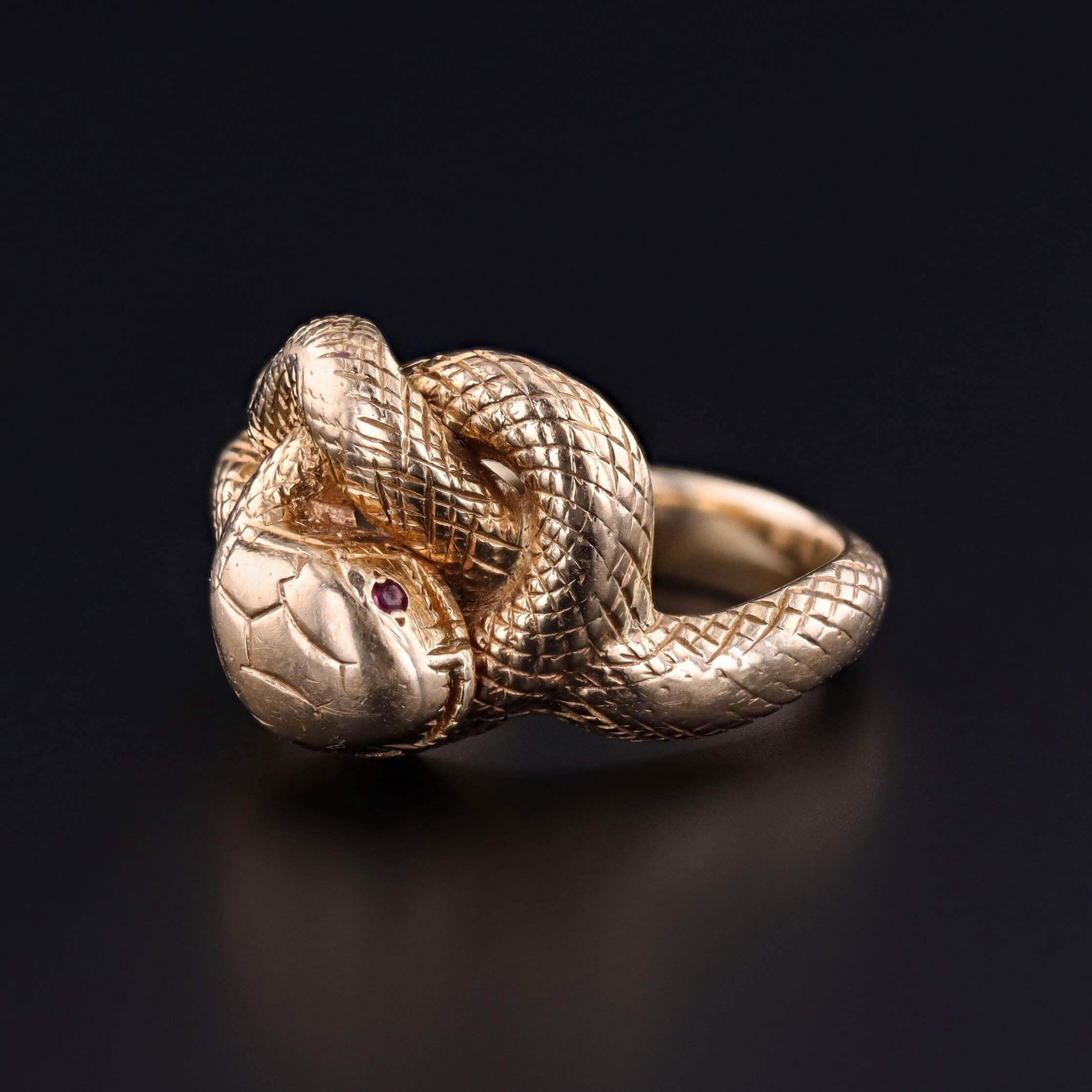 Un affascinante anello a forma di serpente d'epoca tardo-vittoriana (circa 1880-1900), con un serpente annodato splendidamente scolpito in oro massiccio 18 carati, con la testa incastonata da due occhi di rubino. Simboleggiando l'eternità, la