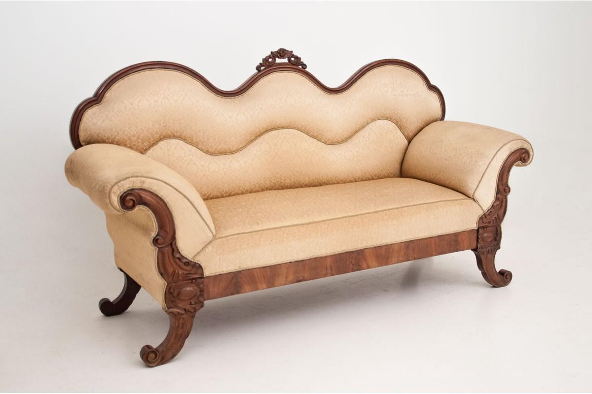 The stylish sofa was made of mahogany wood at the end of the 19th century. The sofa with a very curved stile outline, fully upholstered with elegant fabric, supported on the original curved legs. An excellent choice for a stylish living room. Very