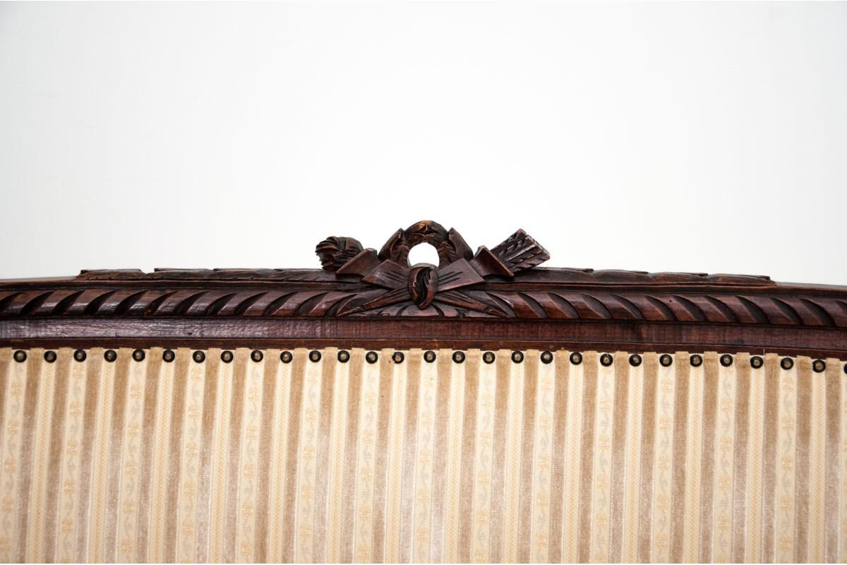 The stylish sofa was made of walnut wood at the turn of the century. Stile beautifully carved, subtle but effective crown on the tops. Fabric upholstered furniture finished with original decorative nails in very good condition, it is possible to