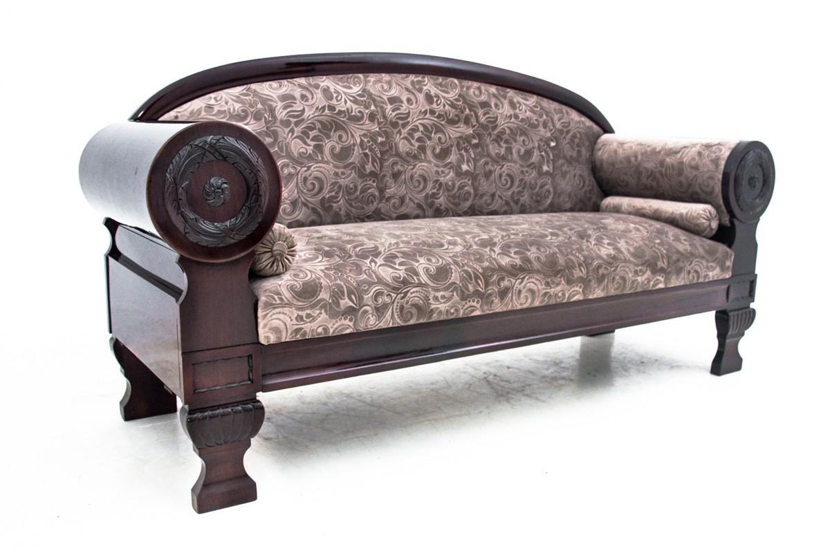 Biedermeier-Sofa. Ein antikes Möbelstück mit einer schönen Form verleiht jedem Interieur Eleganz. Eine Couch im klassischen Stil, gepolstert mit einem eleganten Stoff auf Sitz und Rückenlehne. Die massiven, mit Medaillons verzierten Armlehnen auf