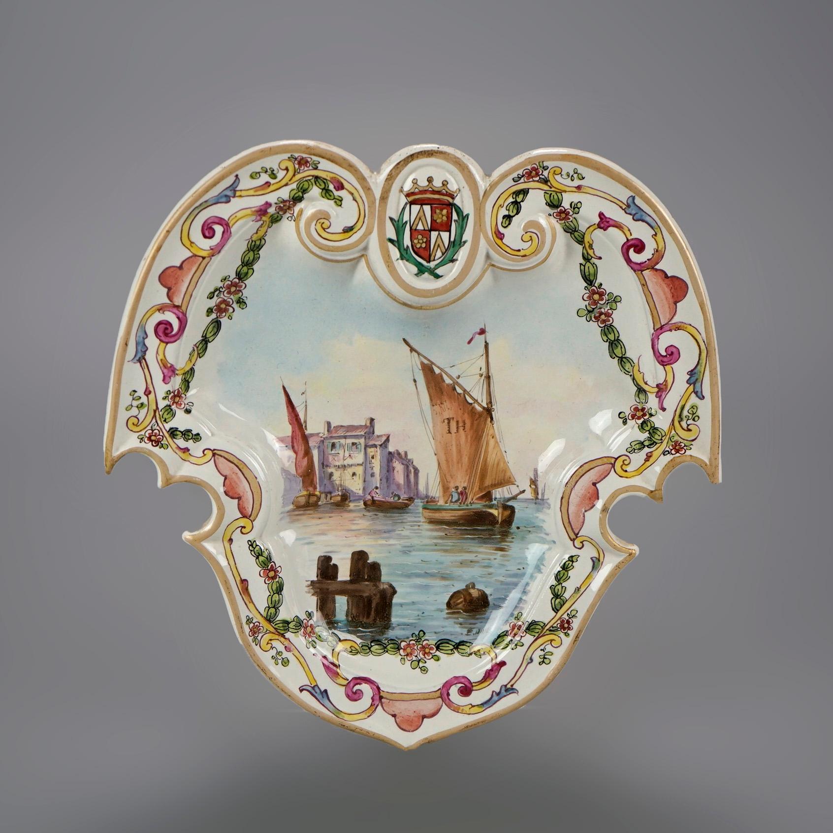 A pair of antique French soft paste faience porcelain plates by Lille offer shield form with hand painted maritime scenes, gilt highlights throughout, and maker mark en verso as photographed, 18th century

Measures- 9.5''H x 9.25''W x 1.5''D.