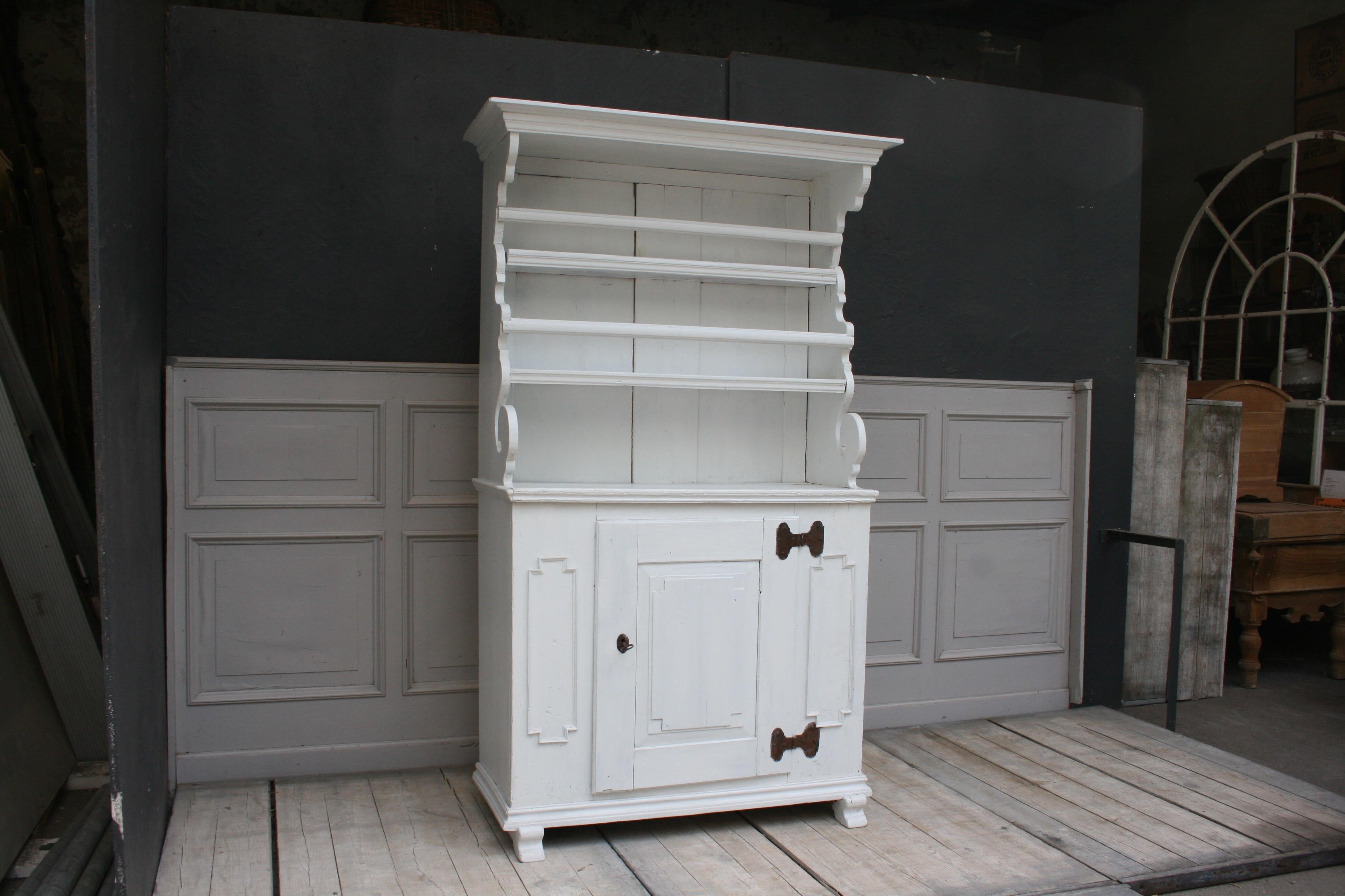 Antique softwood plate board cabinet, restored and painted white by hand. Comes from a country house in northern Germany. The upper part formerly housed plates and pots, in the lower part could be stowed other kitchen utensils.

 