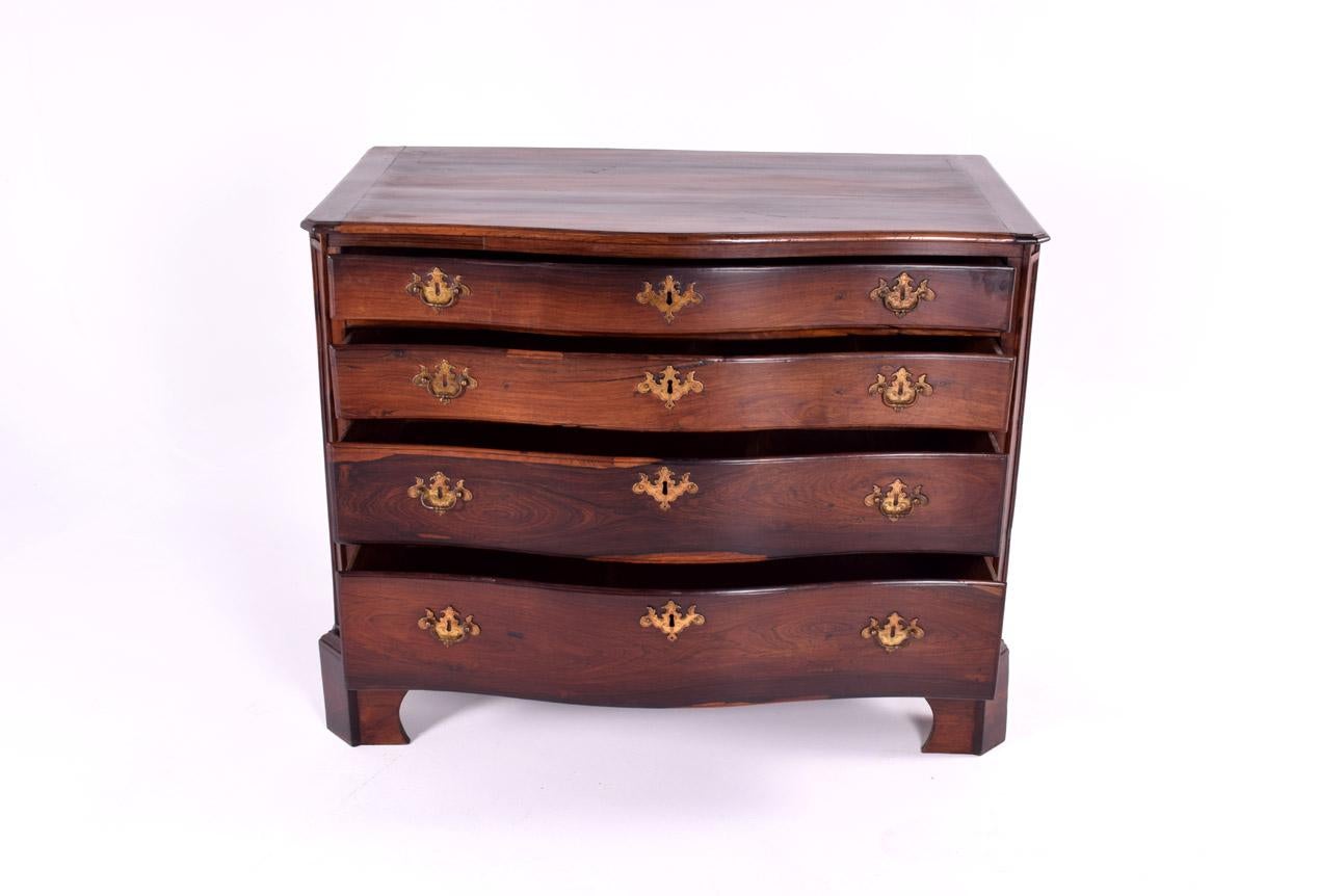 La commode portugaise antique présentée est un exemple frappant de l'artisanat du milieu du XVIIIe siècle. Construit en bois de rose massif, il présente une teinte riche et profonde, typique d'un bois de haute qualité privilégié à cette époque pour