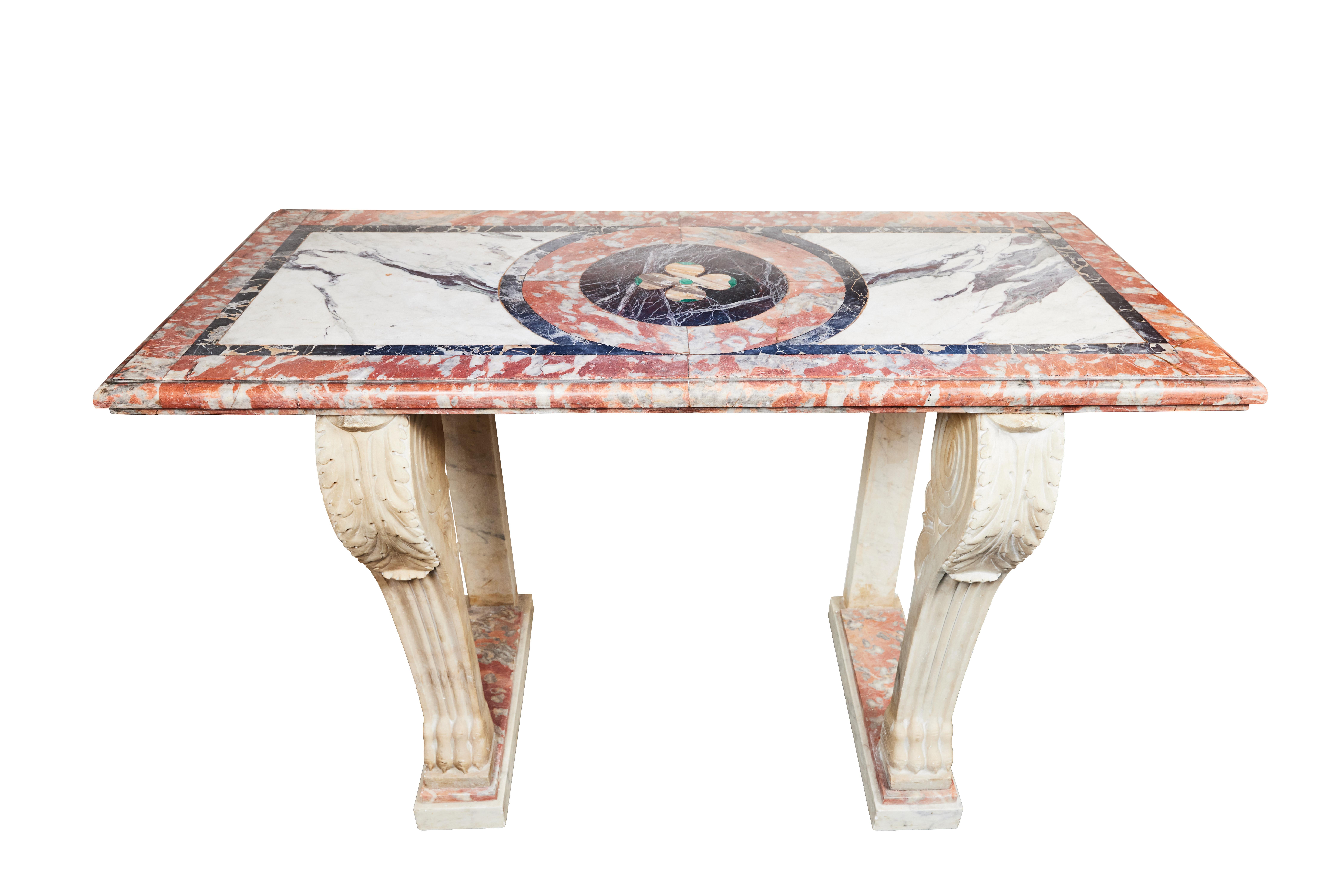 A vibrant, 19th century, French, solid marble, multi-hued console table featuring an inlaid top centered on a clover medallion. The hand carved base has convex legs with acanthus leaf reliefs above fluted pilasters. Each terminating in stylized claw