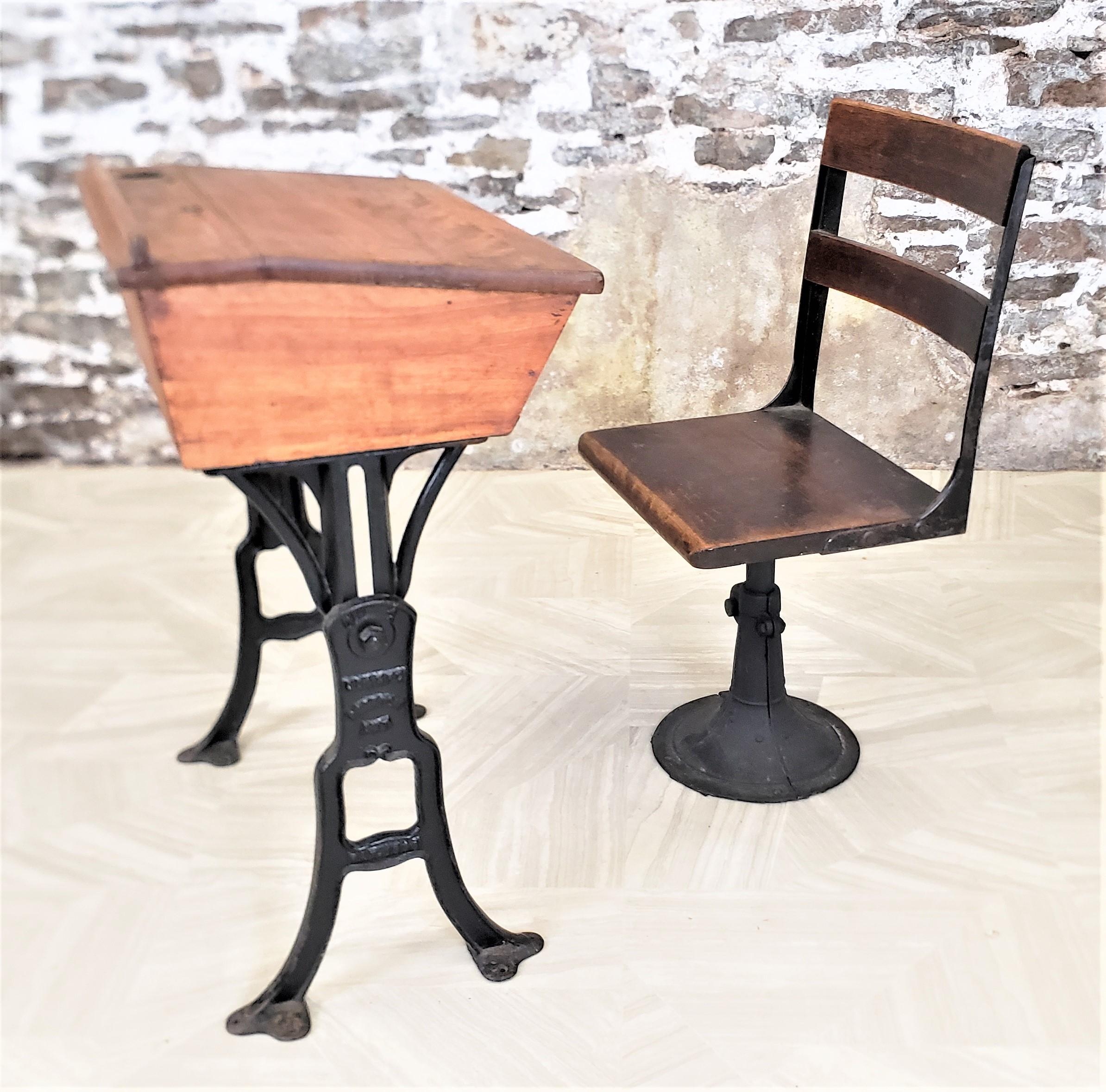 This antique desk and chair set originates from Canada and dates to approximately 1920 and done in a period Art Deco style. The desk and chair are composed of solid oak and the bases are done in a cast iron. The top of the desk is a solid oak box