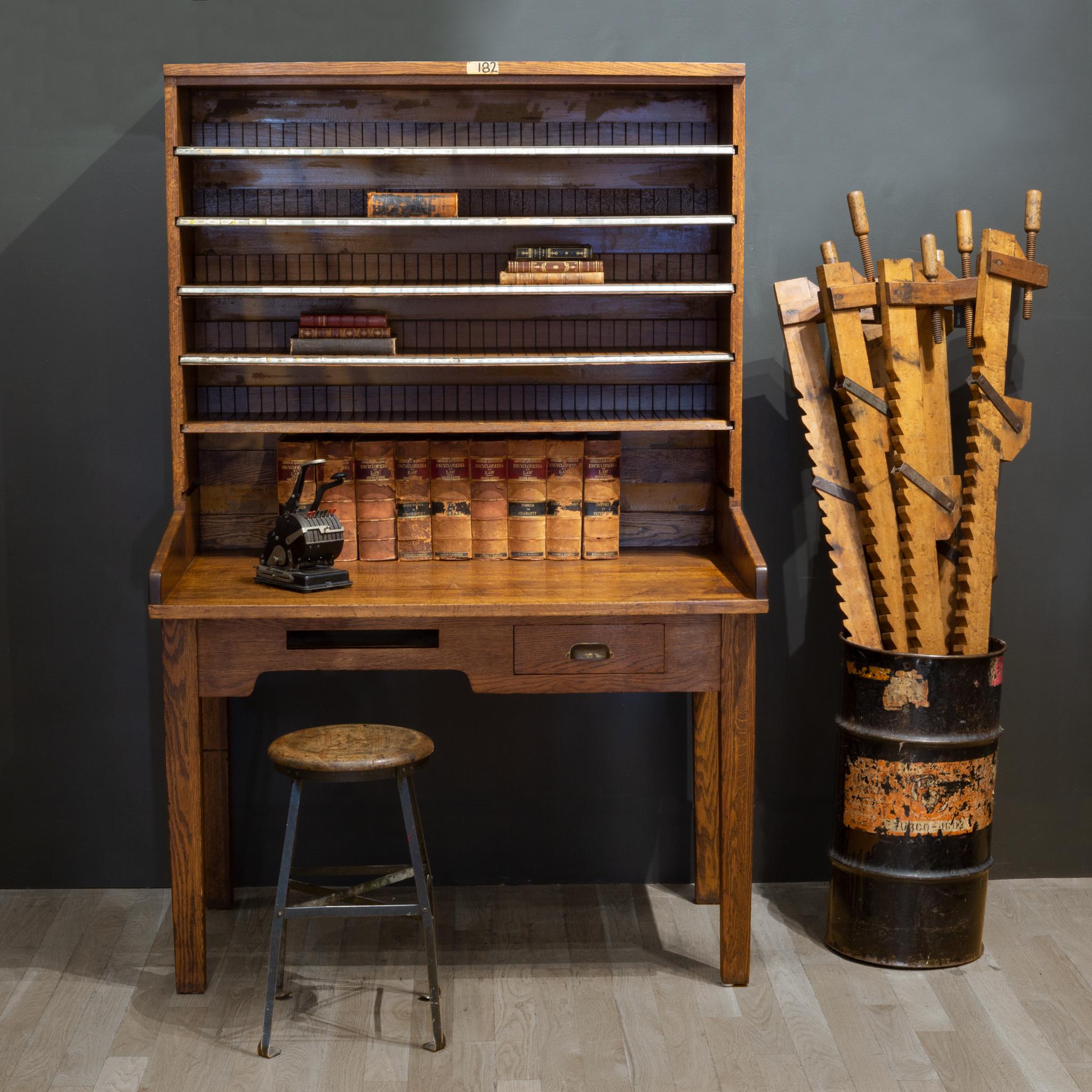 About

An antique solid oak postal desk with several removable shelves, drawer with brass handle, document slot and postal messenger bag hook underneath. Each shelf has slots for letters and original labels. The desk is stamped on the the top