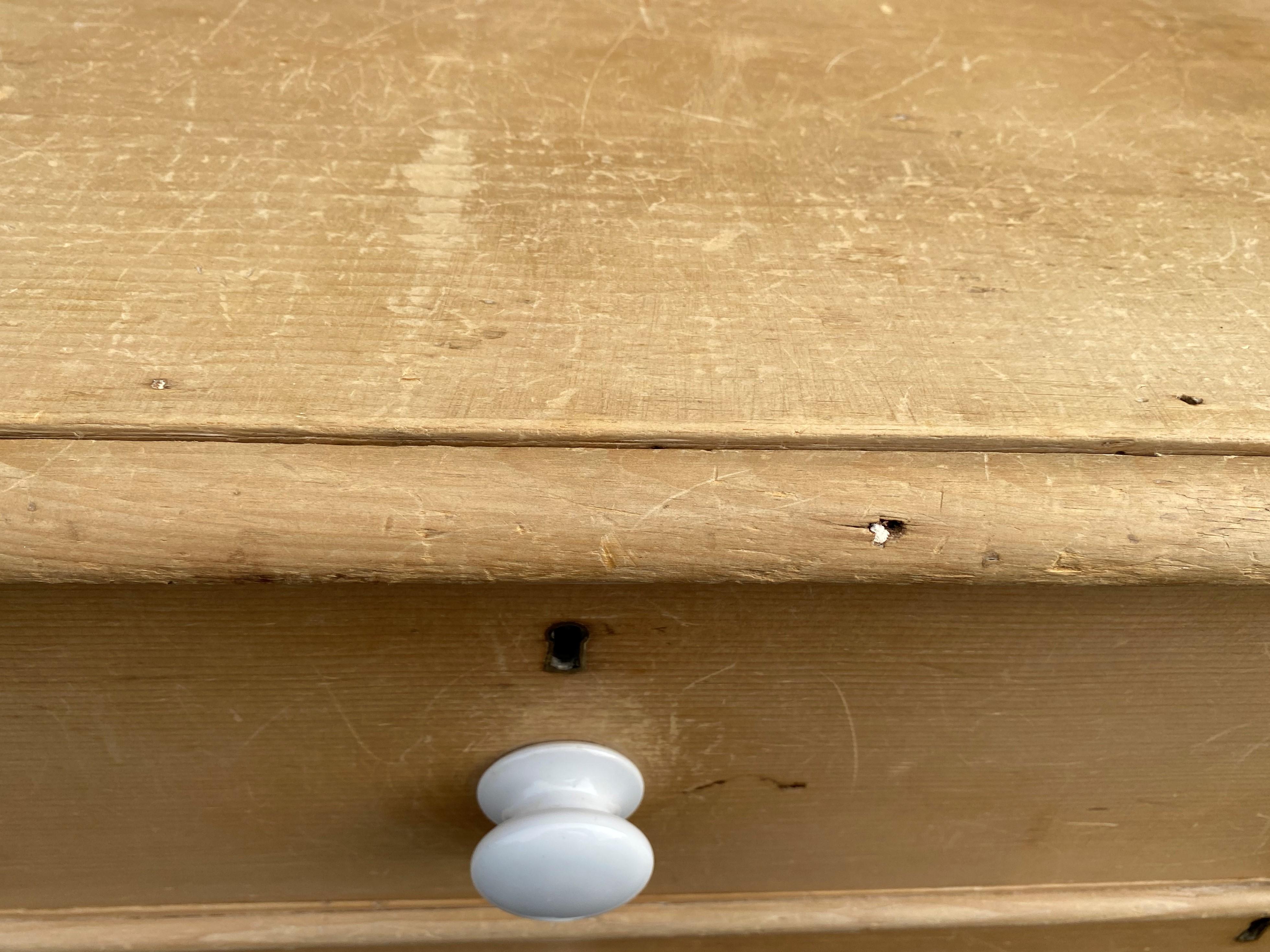 Solid pine dresser with original white ceramic pulls. Over 200 years old and made with hand forged nails and dove tail drawers. This piece has been painfully disassembled and reglued, the original handmade nails have been reused. The finish is the