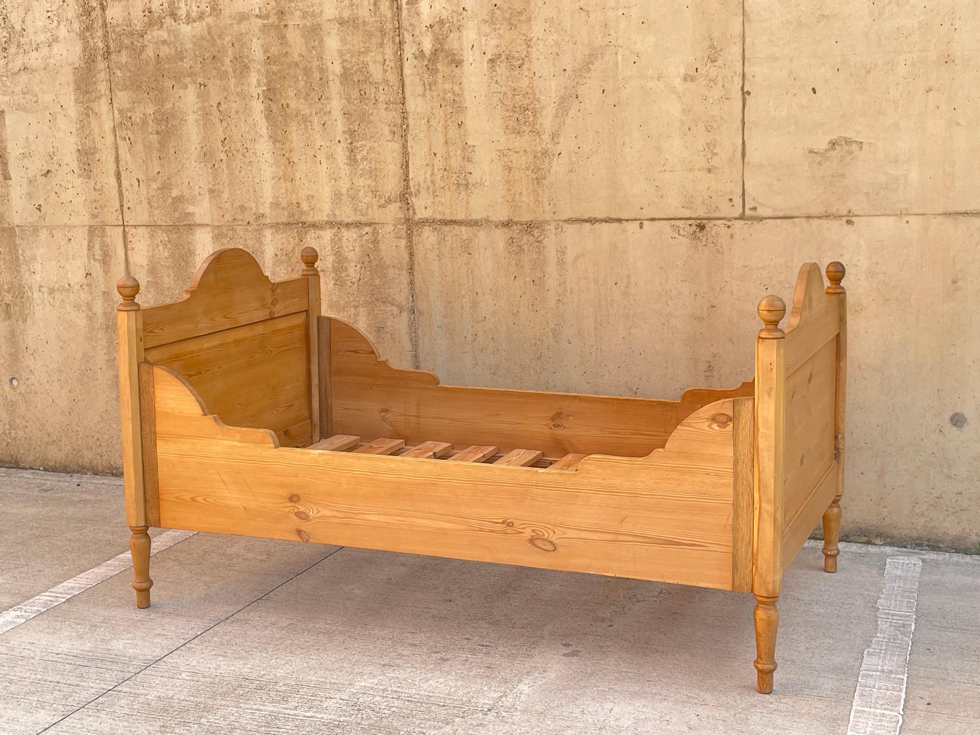 A beautiful solid pine box bed. England Approx C1940.  

This piece is beautifully made with a turned pine leg structural and matching panelled foot and head boards. It has a simple assembly with string metal latches at each end. There a beautiful