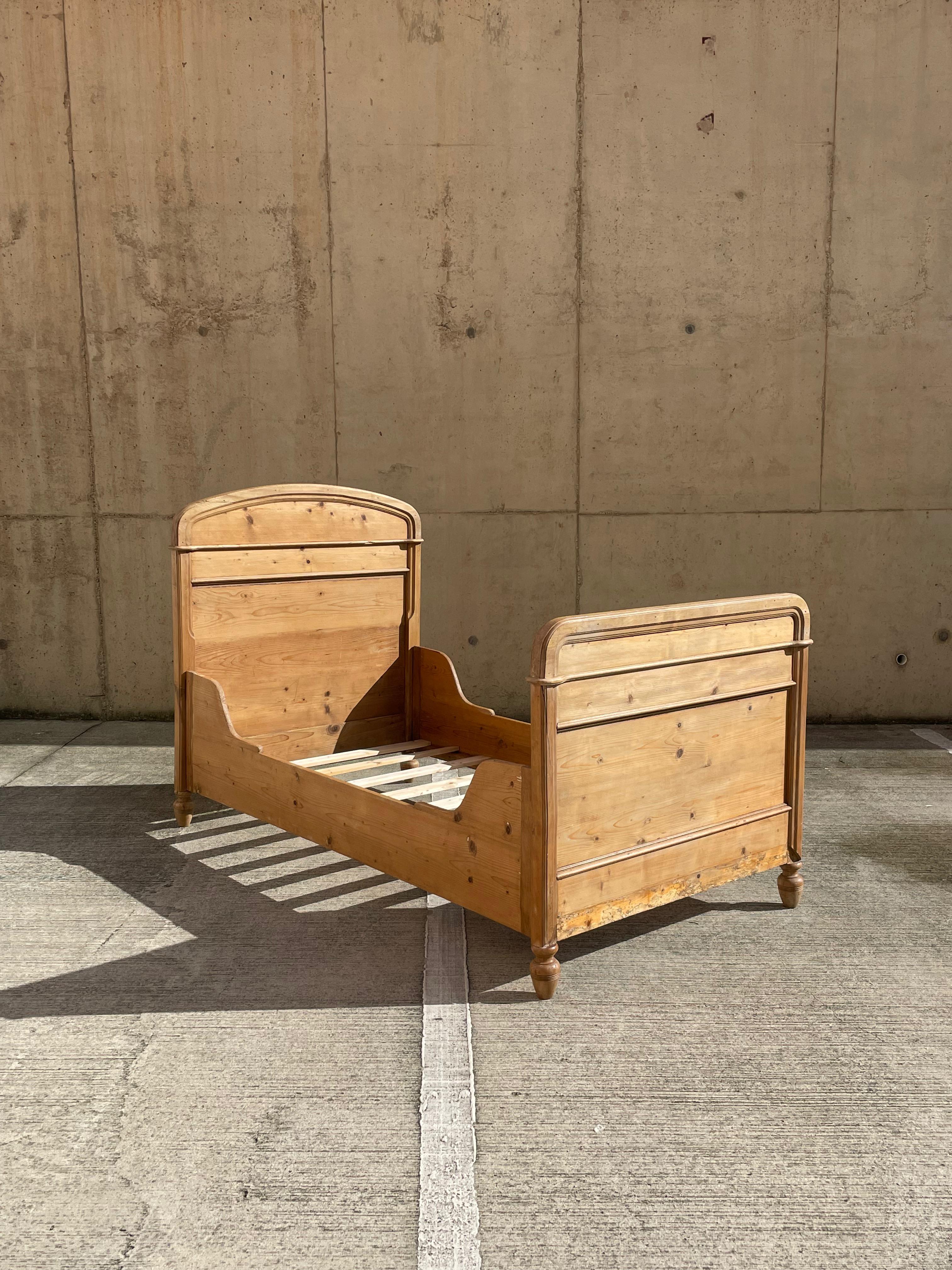 A beautiful solid pine box bed. England Approx C1920.  

This piece is beautifully made with a turned pine leg structure and matching panelled foot and head boards. It has a simple assembly with metal key hole latches at each end. 

This bed is