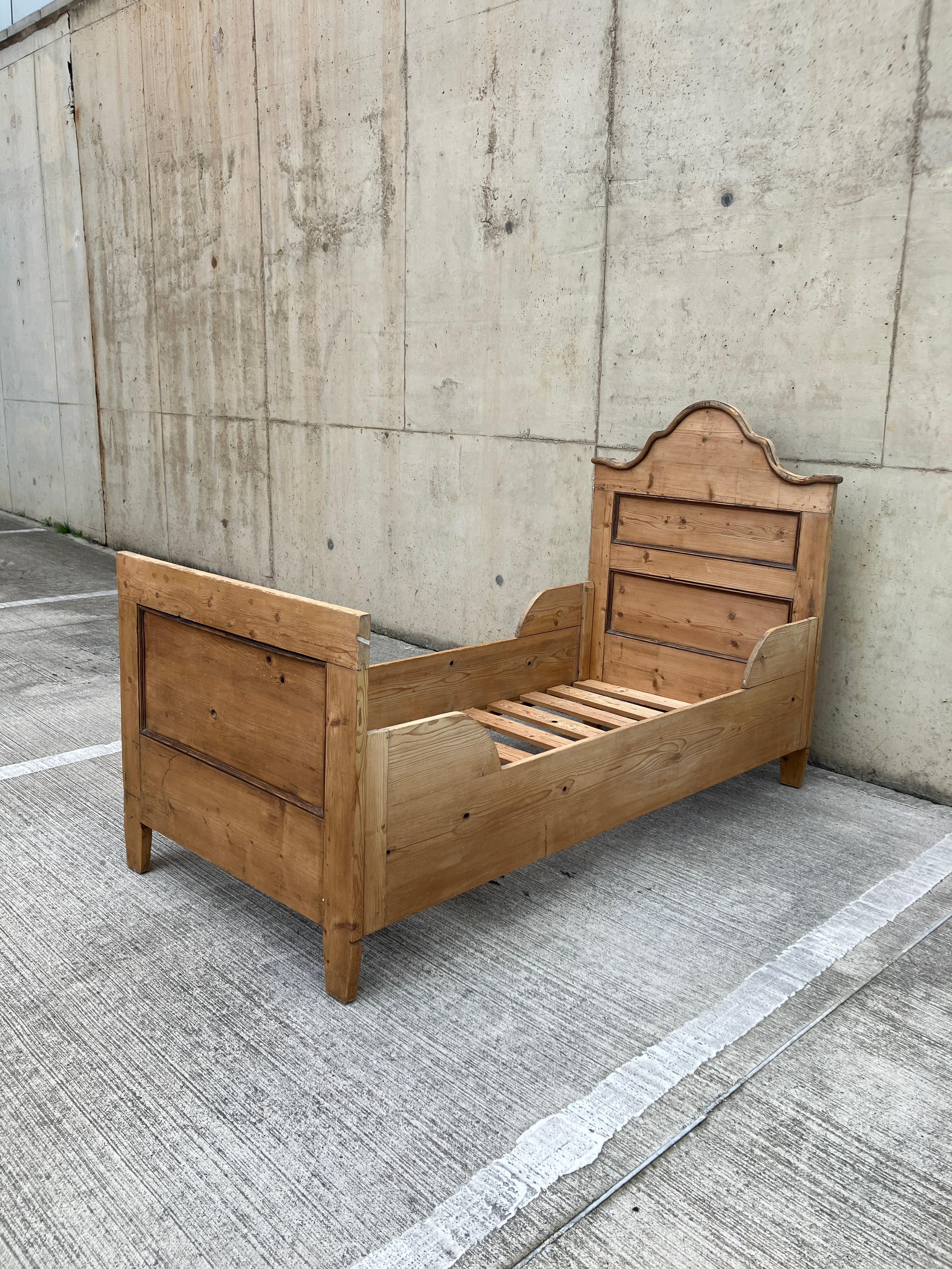 Un lit coffre en pin massif d'Angleterre. 

Ce lit simple antique est magnifiquement réalisé avec des pieds et des têtes de lit et des panneaux latéraux pour former une boîte.  L'assemblage est simple, avec des loquets métalliques en trou de serrure