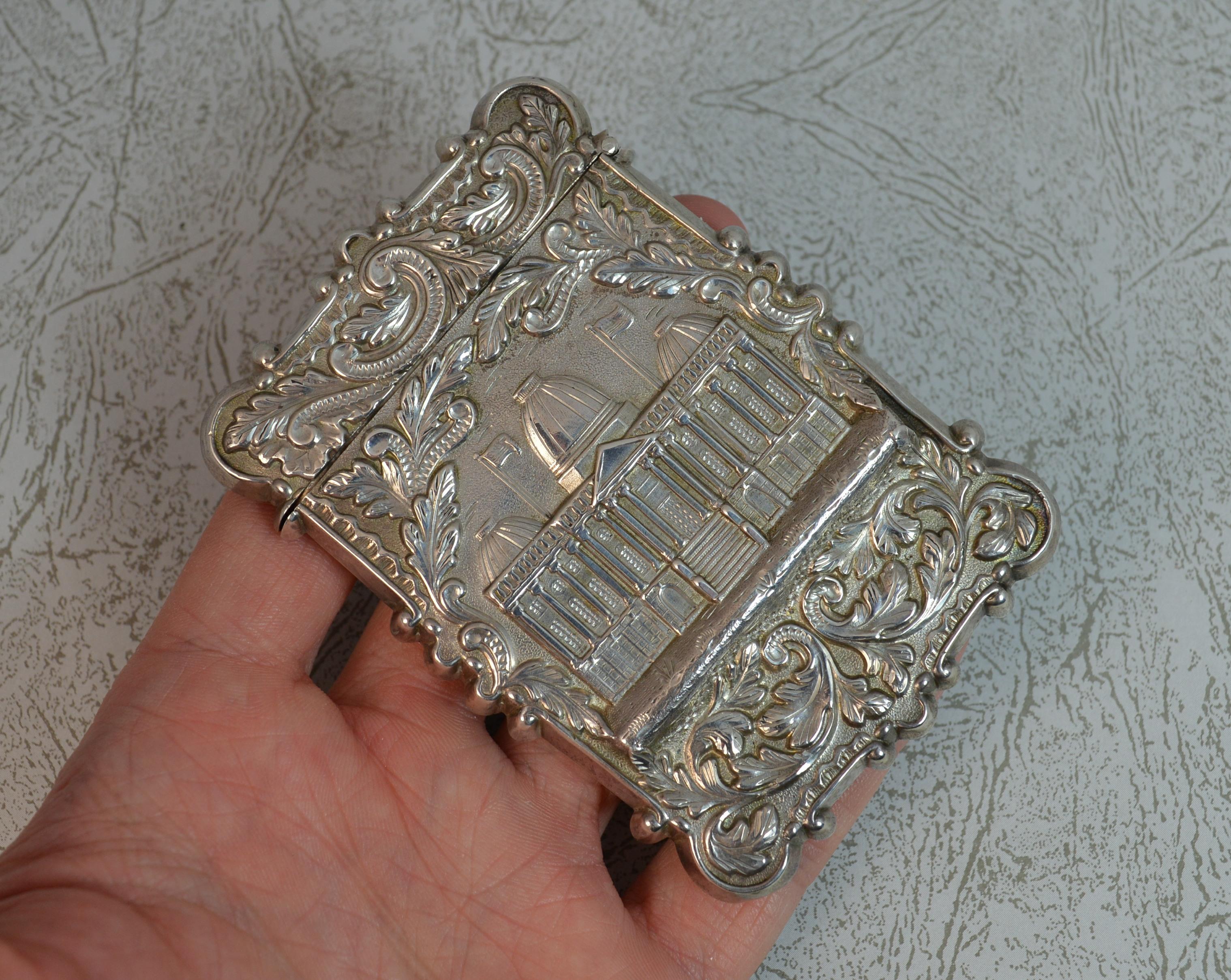 A stylish sterling silver card case or business card holder.
Likely American made.
Designed with floral scrolling to each side. The centre to the front boasts a 3D finish of a building. The reverse with an arrow and horn image.
Hallmarks ; none,