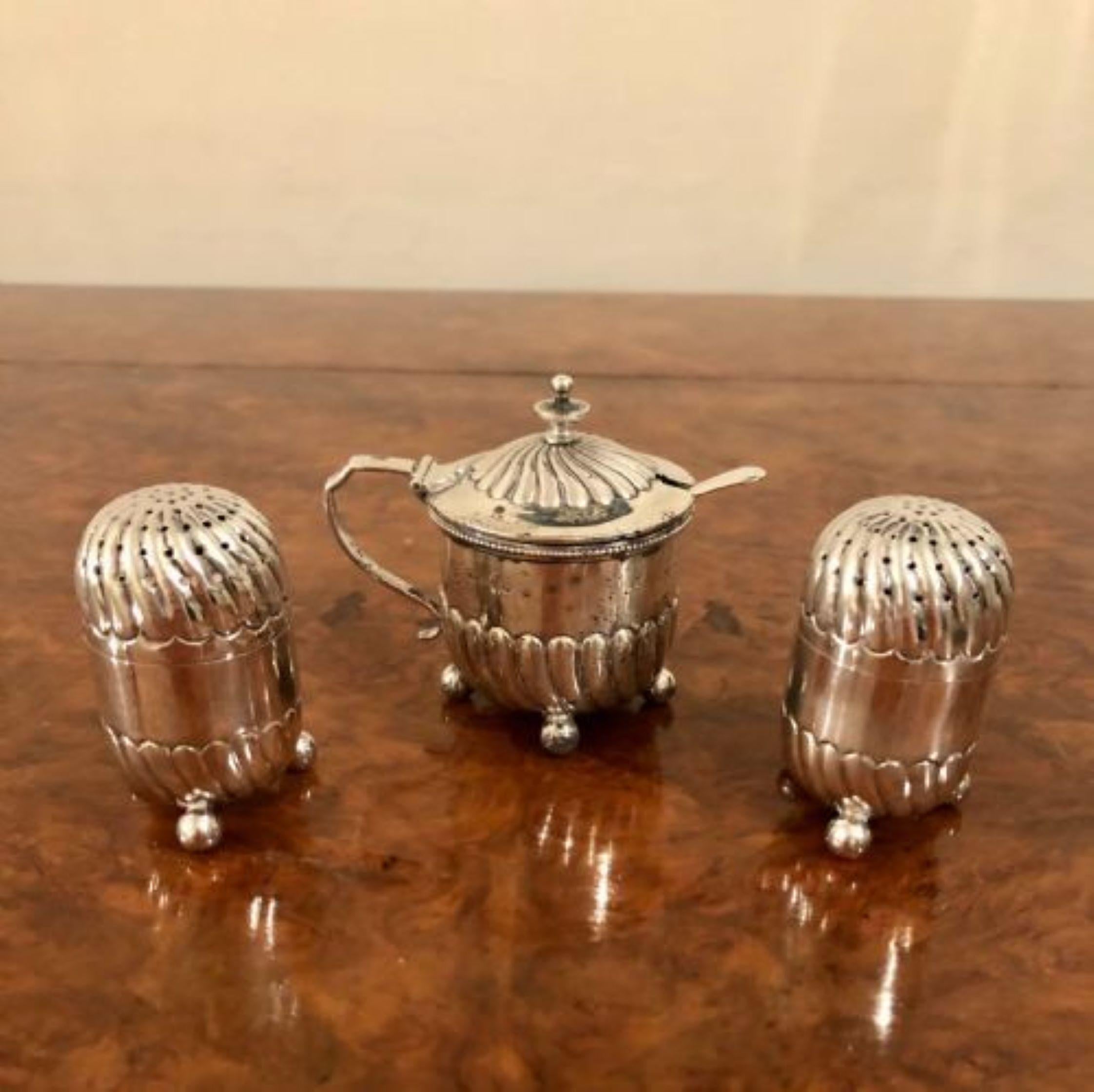 Antique solid silver salt, pepper & mustard pot with shaped fluted bodies standing on ball feet. Salt & pepper pots have removable hall marked tops and the mustard pot having a lift up lid