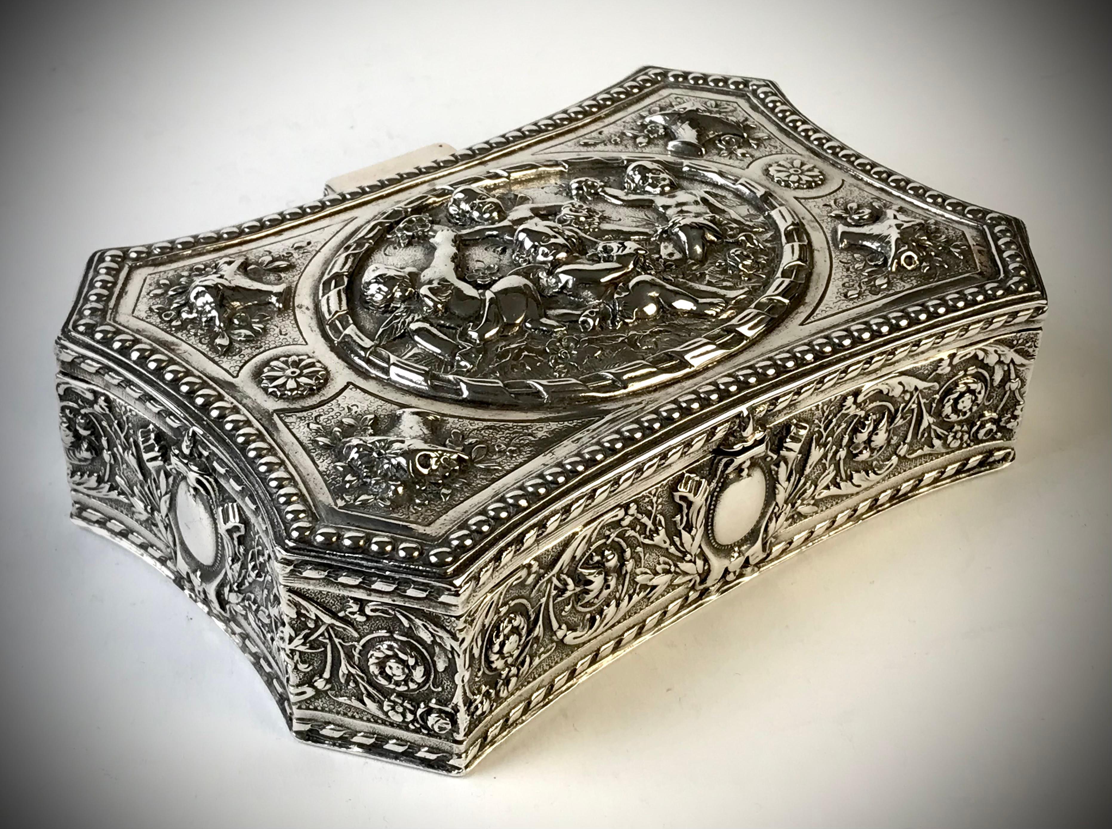 An antique Solid Silver Jewellery box decorated both Putti and baskets of flowers 
Hinged lid with central oval disc with high embossed decoration.

Gold gilded interior 

Hallmarked to the base 800 silver 
Germany circa 1880
Weight 375 grams