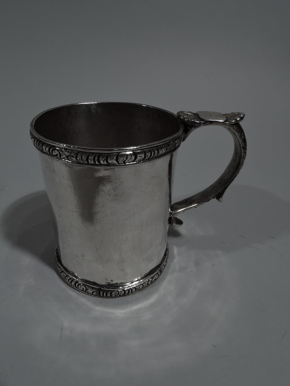 South American silver christening mug, circa 1850. Straight sides and ornamental rims with dense tooled leaves. S-scroll handle with stylized leaf-cap thumb rest and tooled flowers and scrolls. Heavy weight: 9.5 troy ounces.