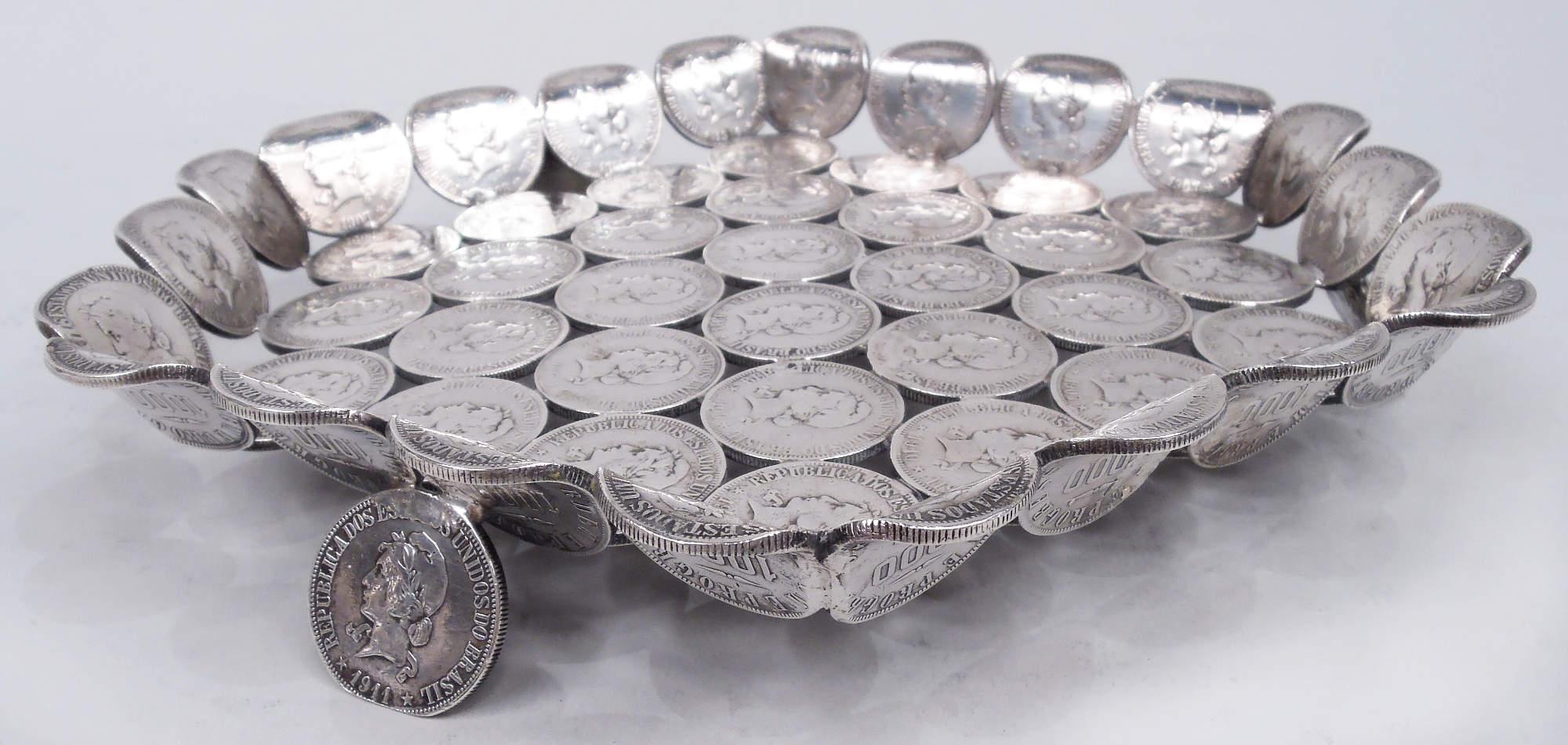 South American dish, ca 1920. Lozenge-form with flared rim and 3 splayed supports comprising Brazilian 1000 Reis coins minted in the first two decades of the twentieth century. A great way to give “currency” to your décor. Weight: 17 troy ounces. 