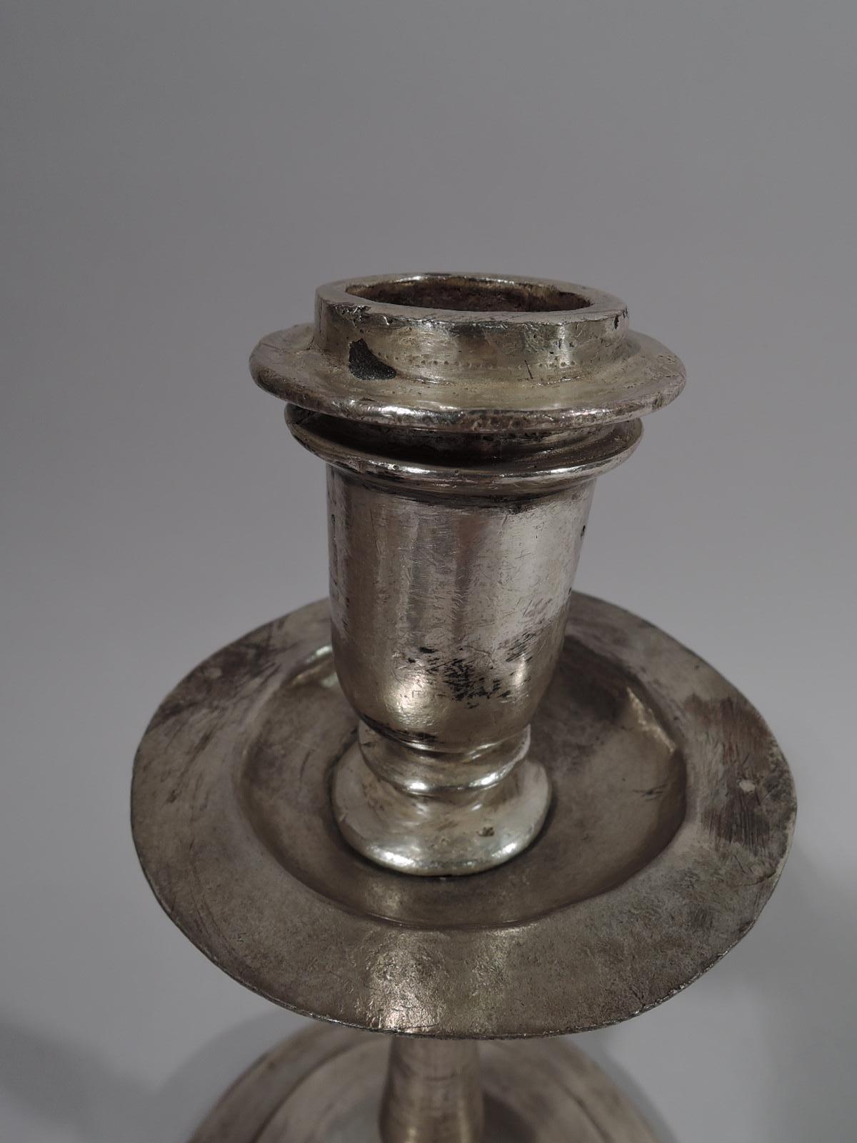 South American silver candlestick, 18th-19th century knapped and baluster shaft on stepped and domed foot. Urn socket and disc wax pan with deep well. Weight: 20 troy ounces.