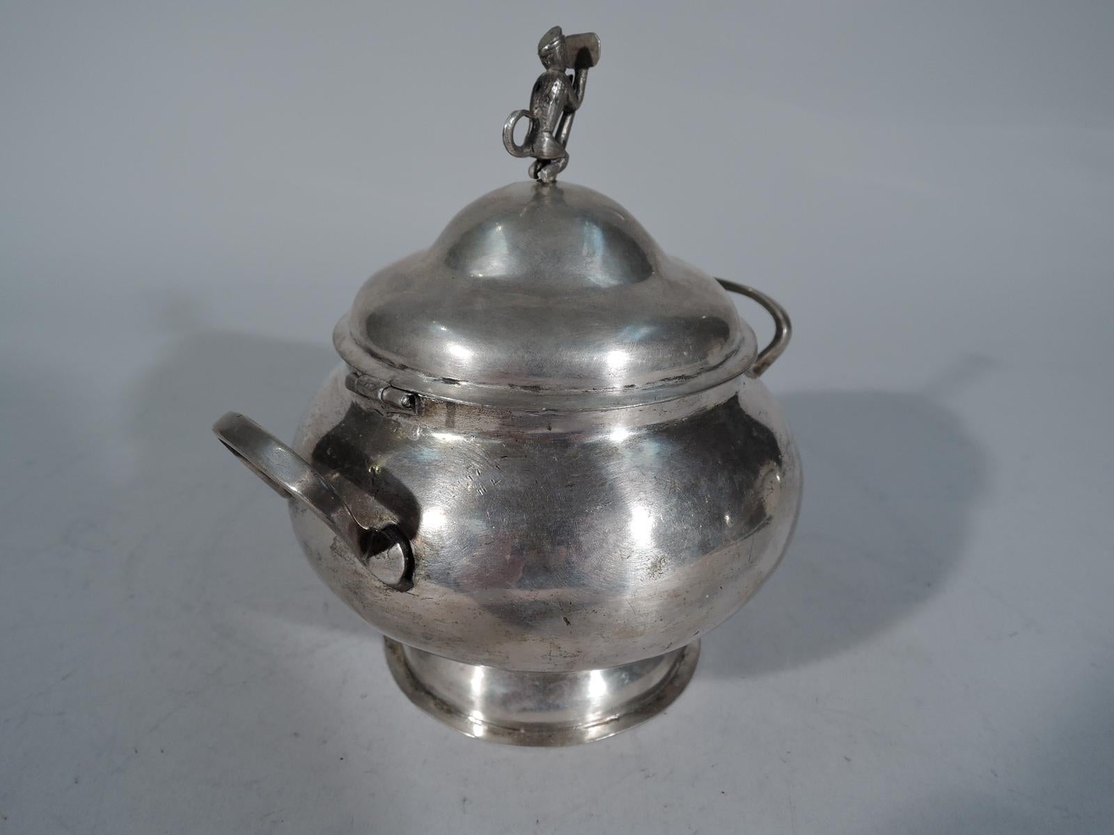 South American silver sugar bowl, late 19th century. Bellied with scroll-bracket end handles, domed foot, and hinged double-domed cover with figural finial in form of crouching monkey leaning against a sign post engraved with initials DB. Hand