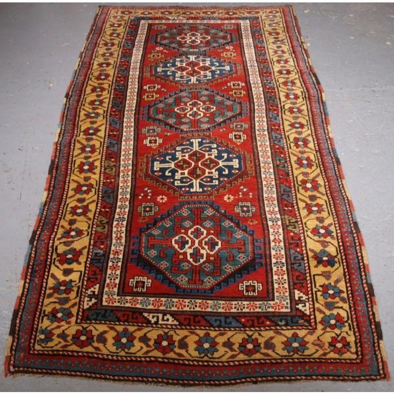 Un tapis long ancien de la région du Karabagh, dans le Caucase du Sud, avec une rangée verticale de cinq octogones sur un fond rouge clair. C'est un exemple vraiment exceptionnel de tissage caucasien. La qualité de la laine est excellente, très