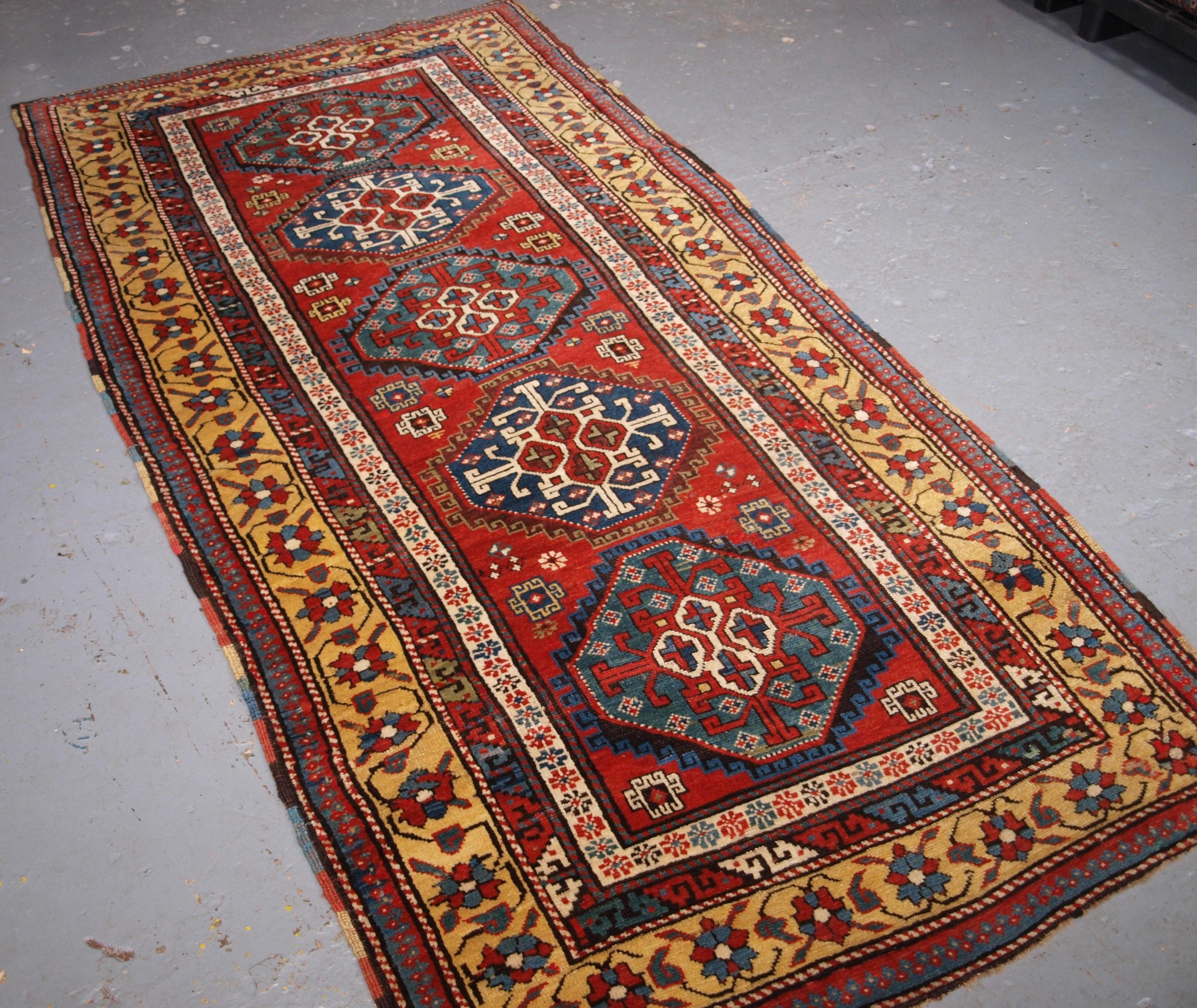 Ancien tapis long de la région du South Antiques Karabagh, avec une rangée verticale de cinq octogones sur un fond rouge clair. Il s'agit d'un exemple exceptionnel de tissage caucasien. La laine est d'excellente qualité, très douce au toucher, et