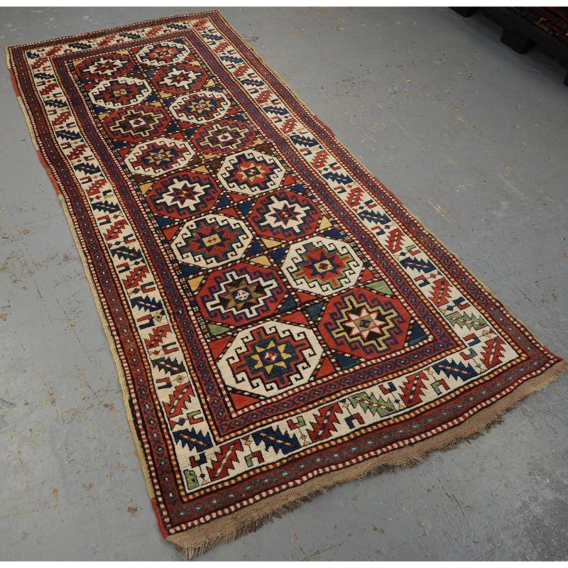 Antique South Caucasian Moghan Kazak long rug with Memling guls within octagons.

A superb Moghan Kazak long rug with two vertical rows of 'Memling guls' within multi coloured octagons. The rug has a traditional Caucasian leaf border design which is