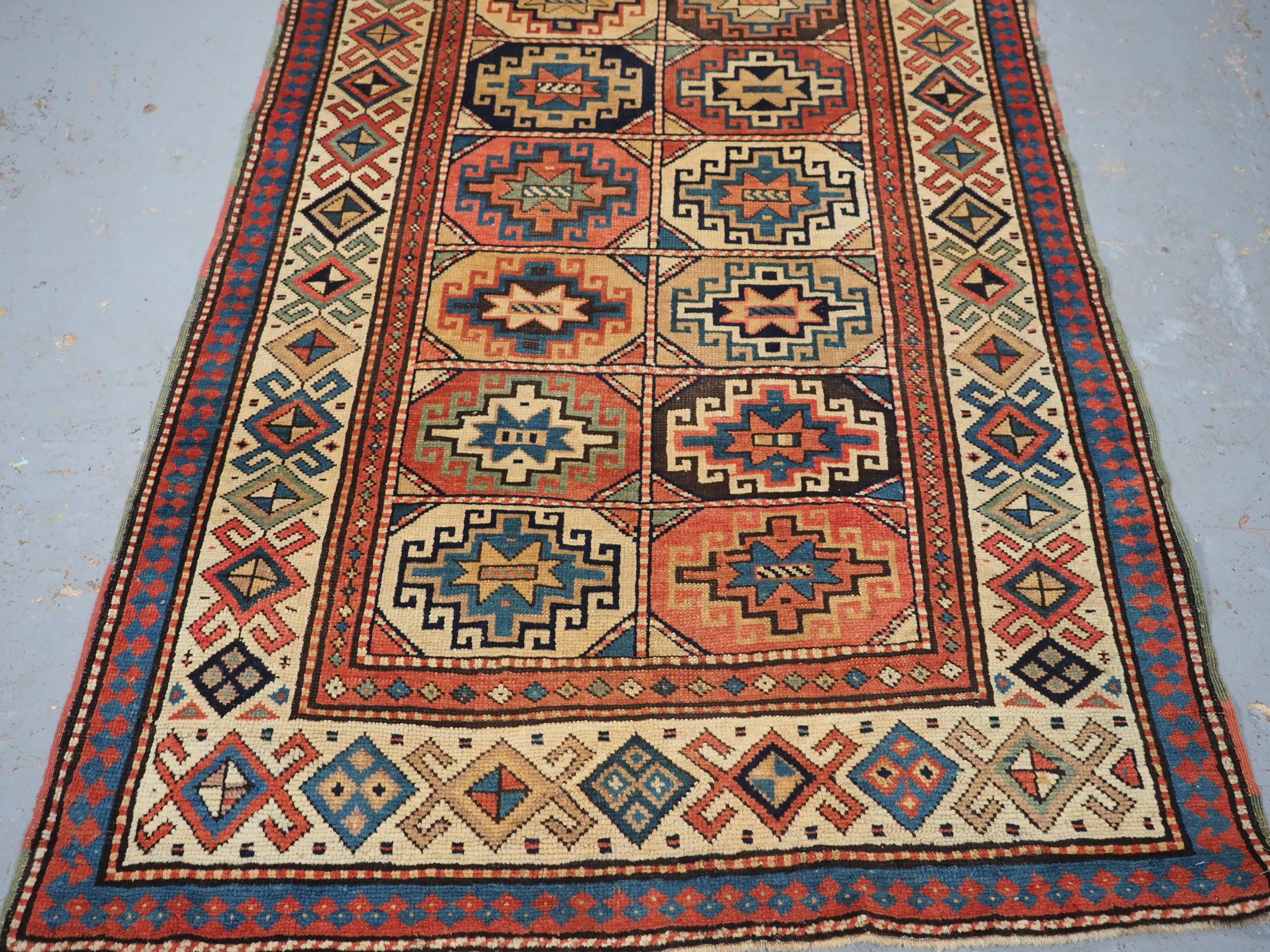 Wool Antique South Caucasian Moghan Kazak long rug with Memling guls within octagons. For Sale