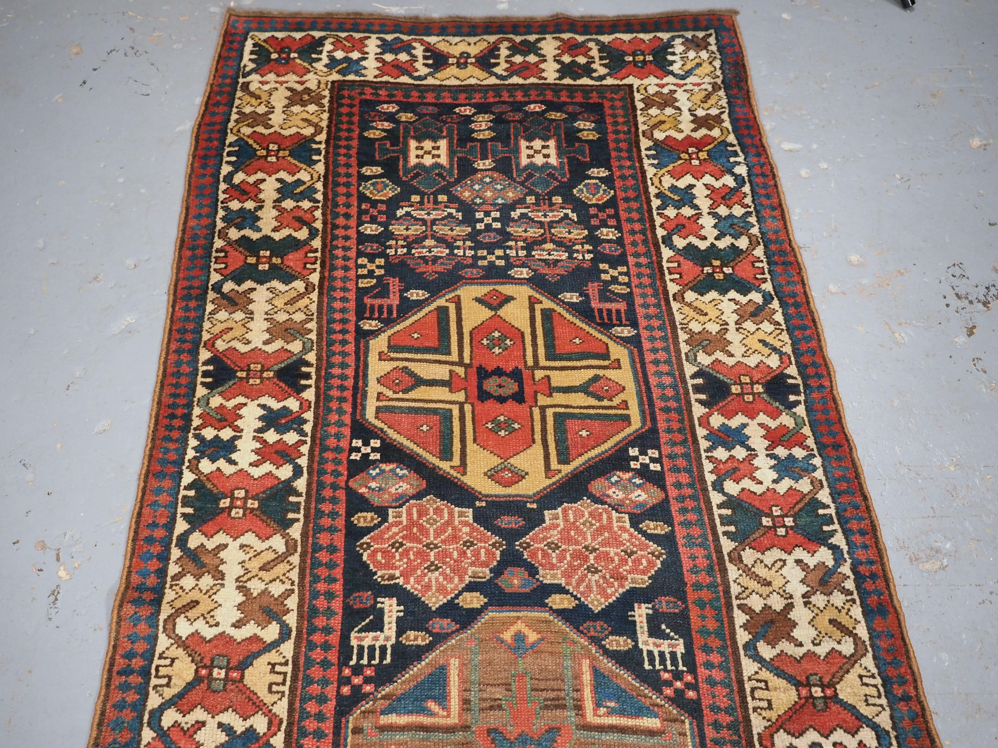 Size: 12ft 10in x 3ft 3in (392 x 99cm).

Antique south Caucasian or Kurdish runner of superb design and colour.

Circa 1890.

A very good runner with octagonal medallions on a dark indigo blue ground, the medallions are all in soft pastel colours.