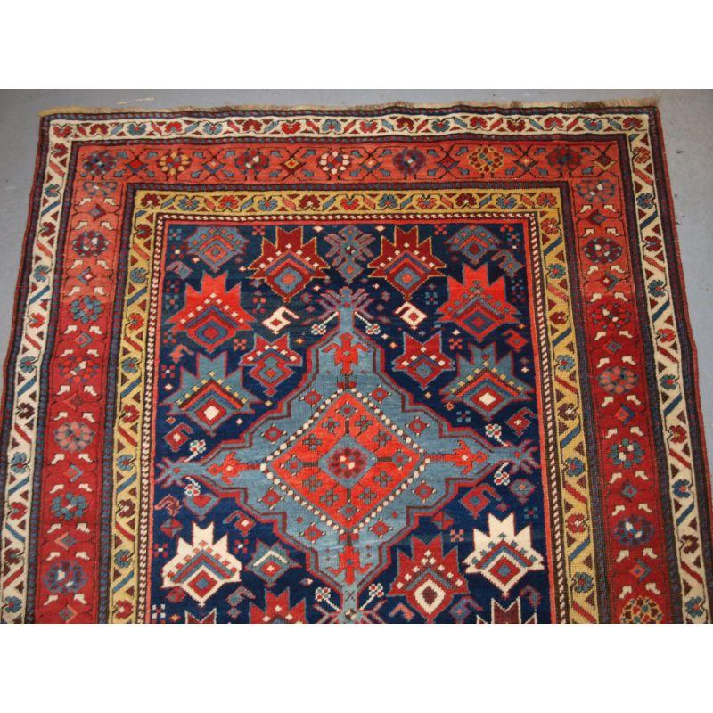This outstanding runner has four linked medallions on a dark indigo blue field. The medallions are surrounded by a very well drawn palmette design. The floral red and yellow borders frame the runner well and contrasts with the indigo blue giving the