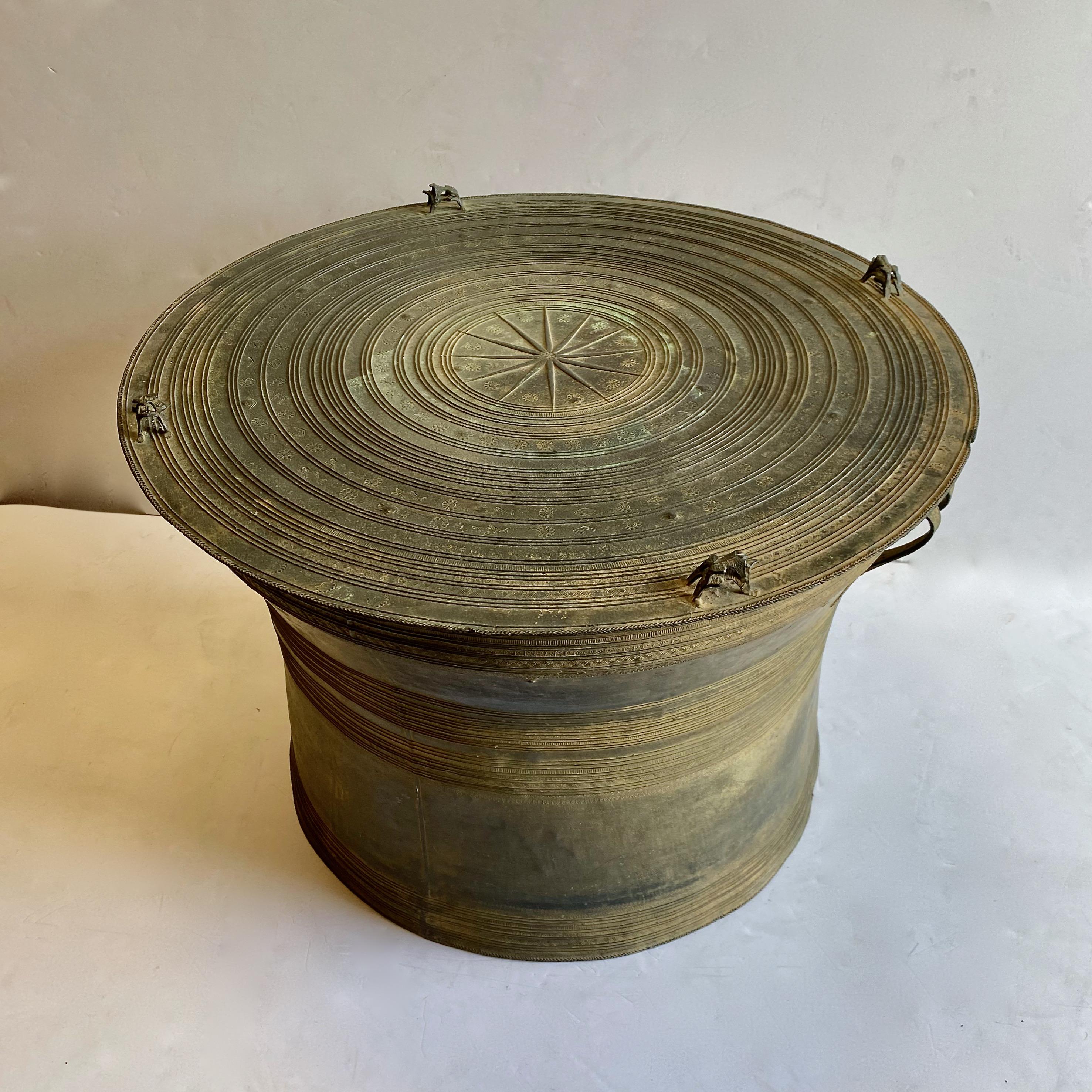This a very large Southeast Asian patinated cast bronze rain drum or frog drum. 
The intended use of the rain drum was ceremonial and was used to invoke rain and serve as an instrument; the drum is currently adapted to serve as a coffee or side